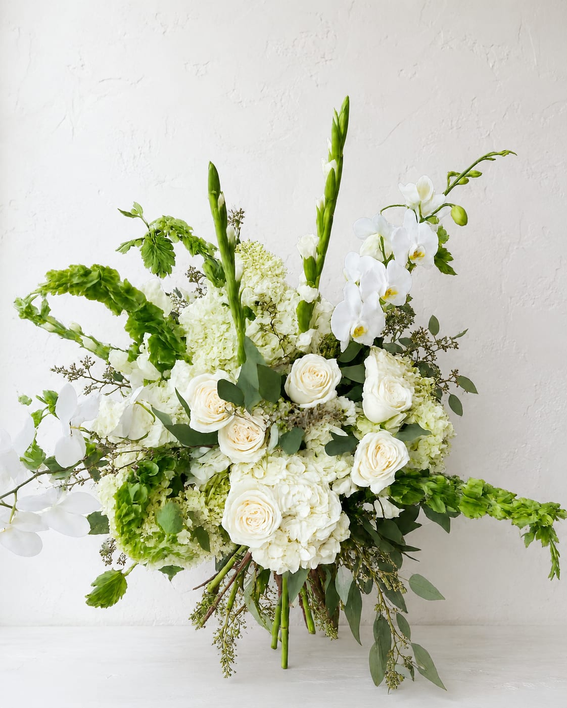 White and green wedding bouquet with roses, orchids, and hydrangeas