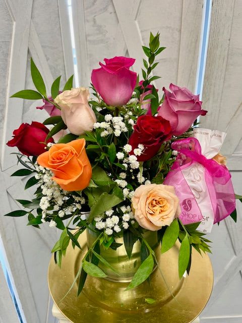 Mixed roses in a gold vase with baby's breath and greenery