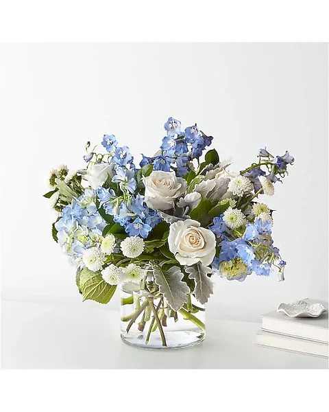 Blue and white flower arrangement in a clear glass vase