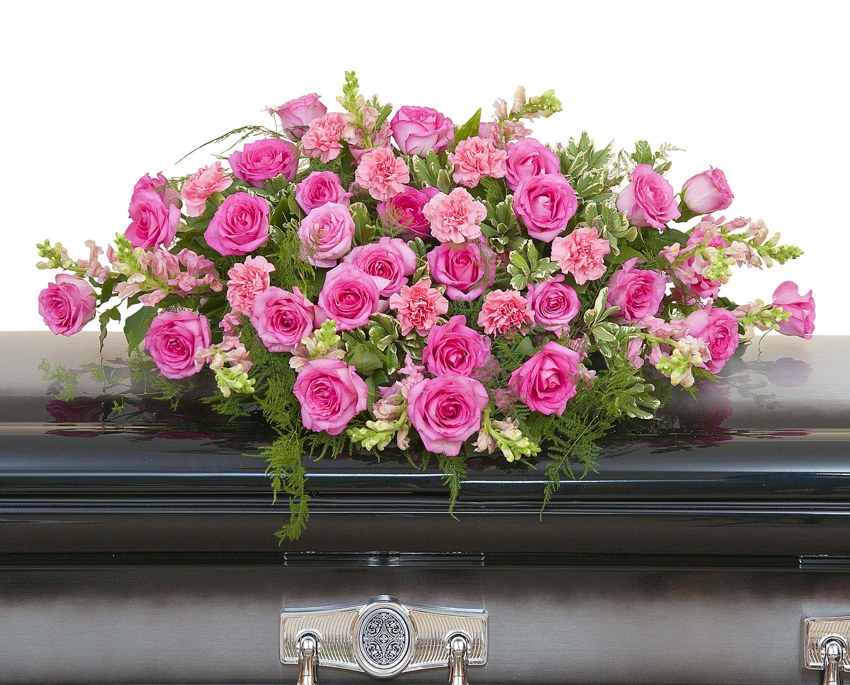 Pink rose and carnation casket spray arranged on a dark metal casket