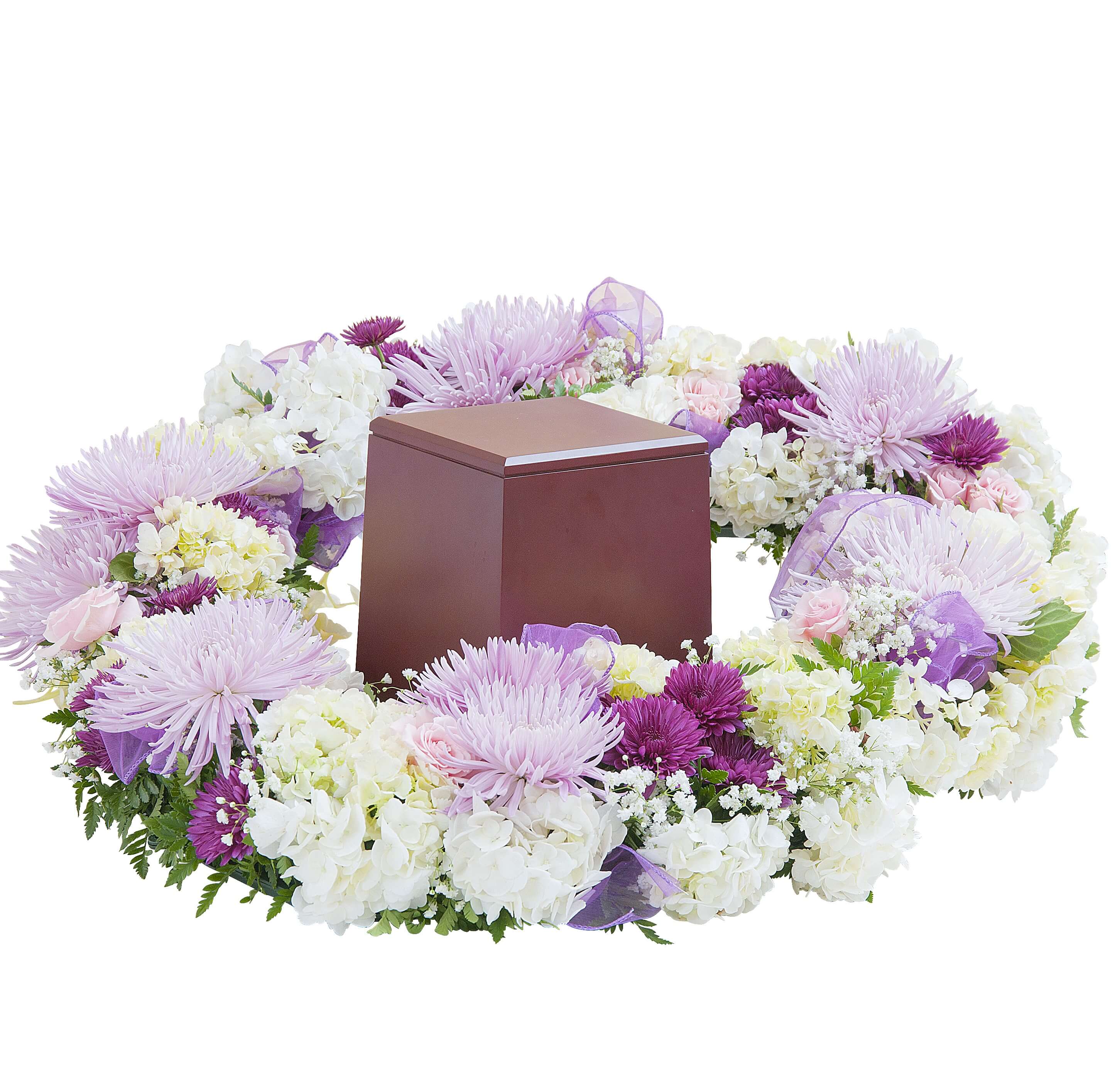 Lavender and white floral wreath surrounding a brown cremation urn box