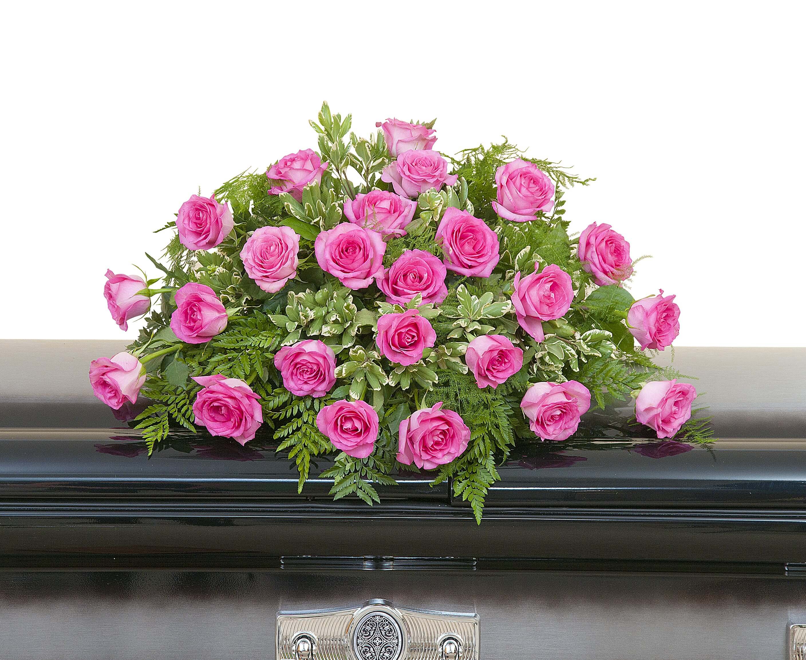 Pink rose casket spray arranged on a dark metal casket