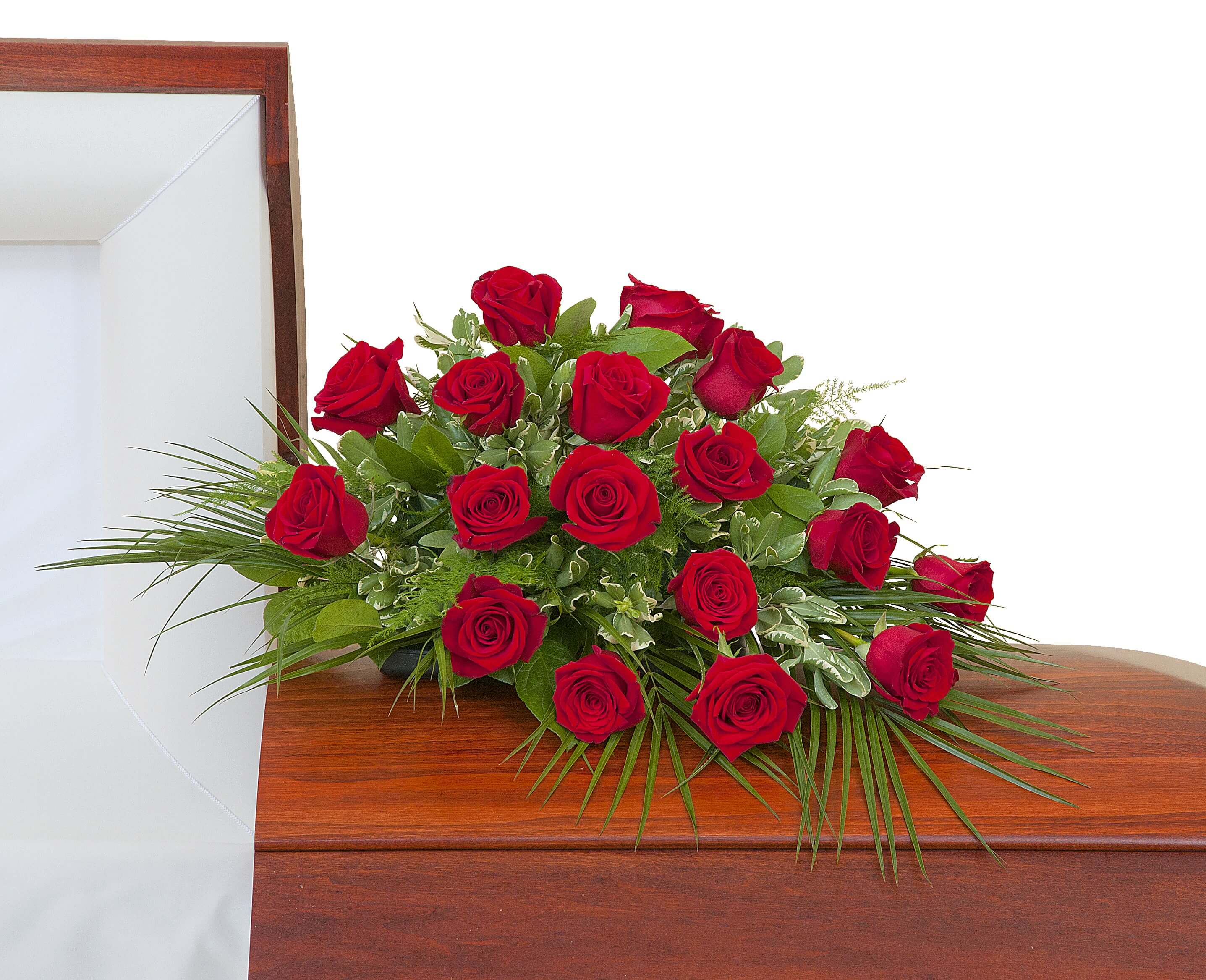Red rose casket spray arranged on a closed wooden casket