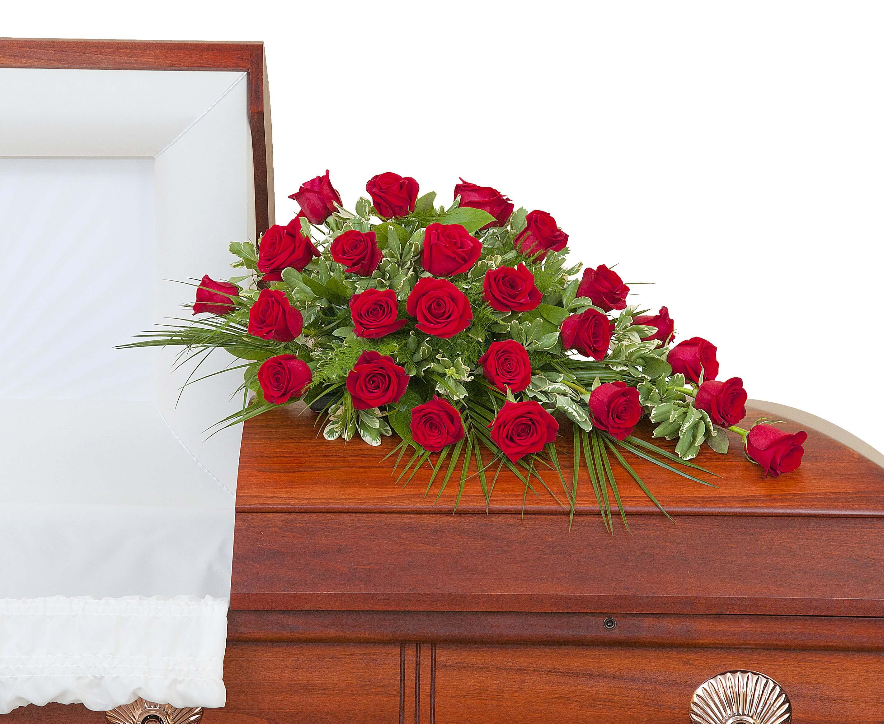 Red rose casket spray arranged on a closed wood casket with white interior