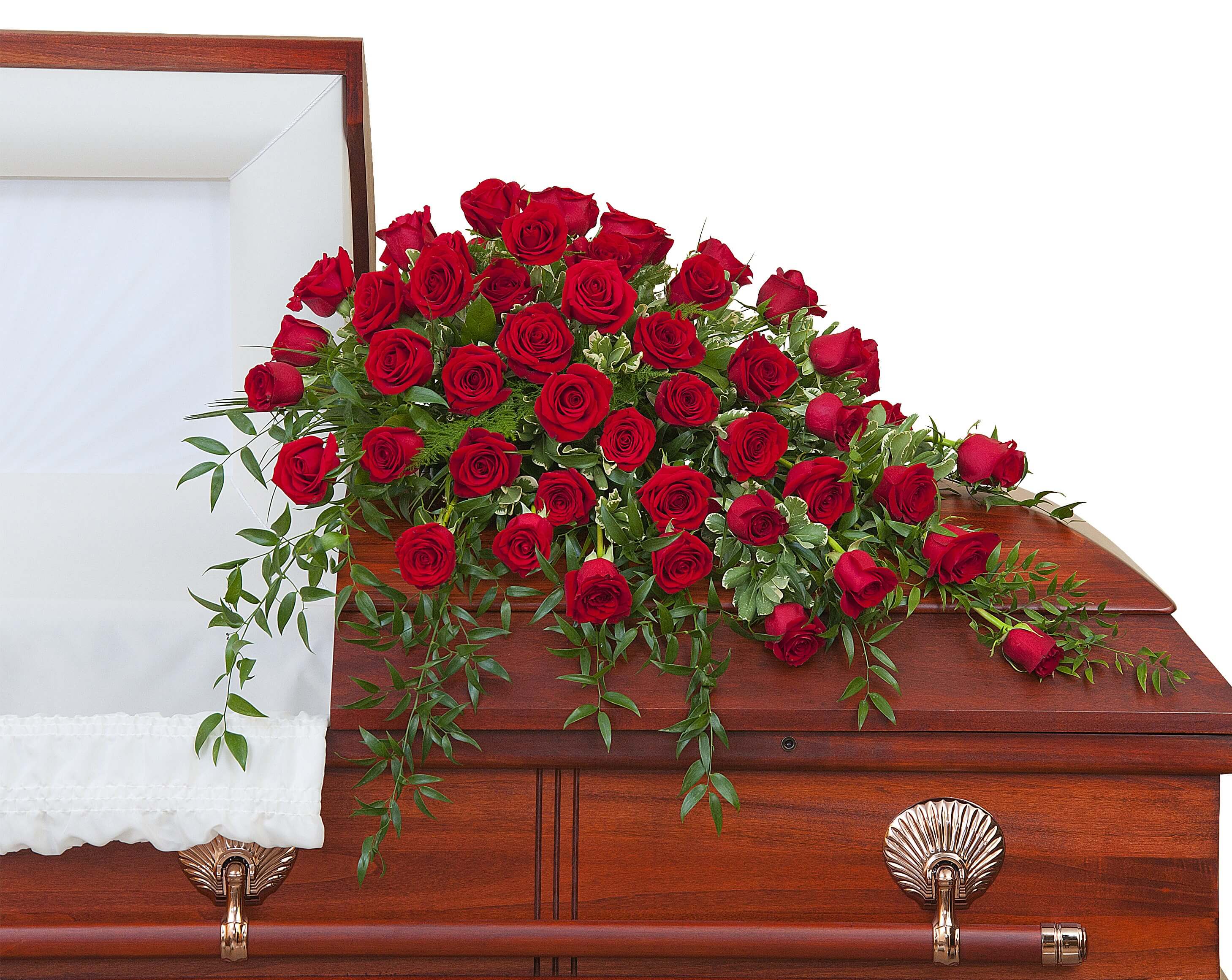 Red rose casket spray with cascading greenery on a wooden casket
