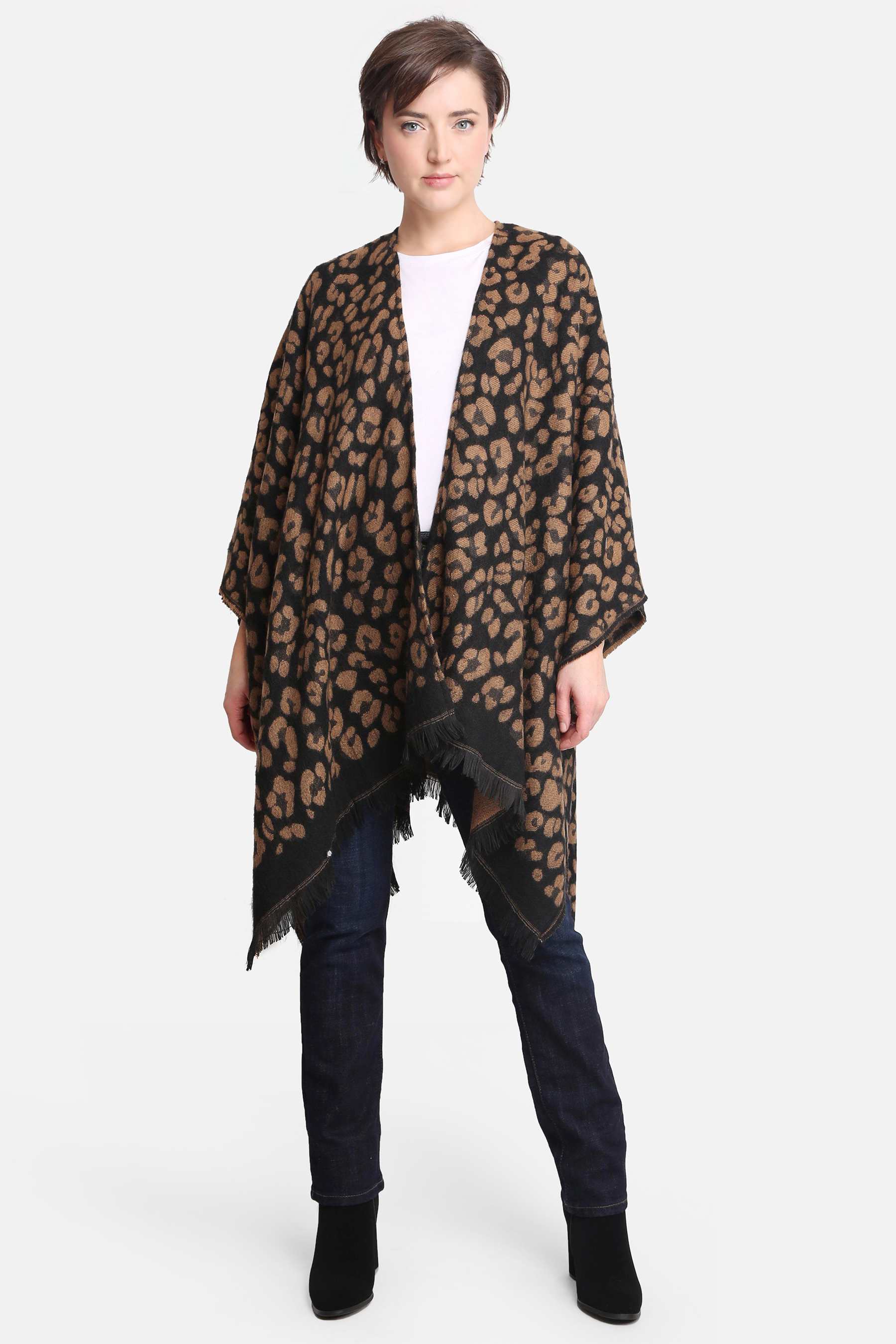 Woman modeling a brown and black leopard print poncho with fringe hem