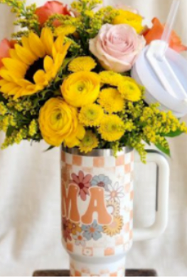 Bouquet of yellow and pink flowers in a decorative mug vase