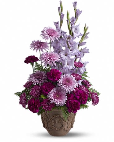 Tall arrangement of lavender and deep purple flowers in a decorative brown pot