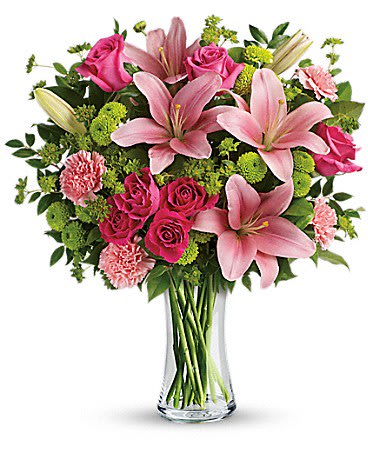 Tall glass vase of pink lilies, roses, and carnations with green button mums