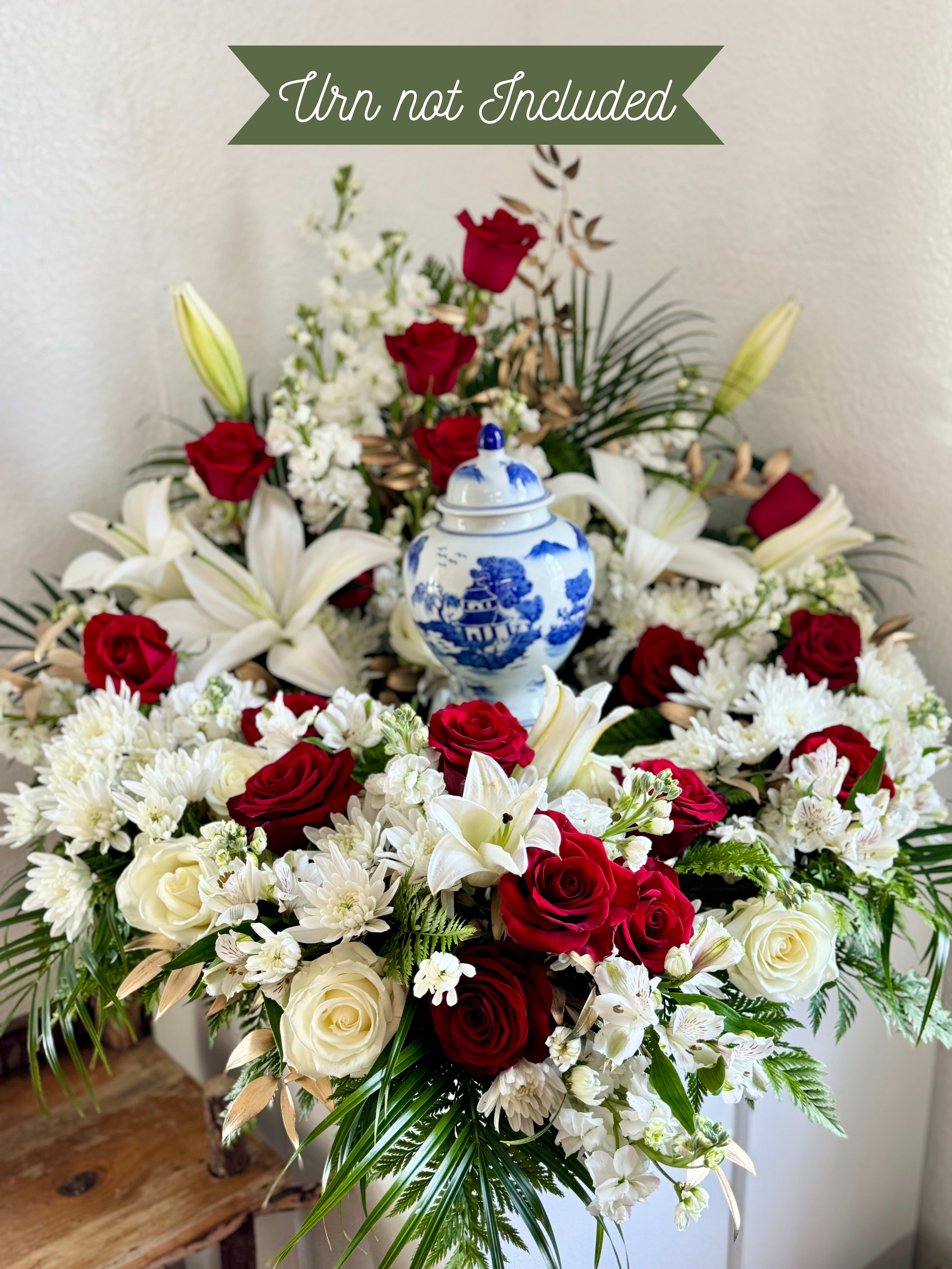 Red and white floral arrangement with a blue-and-white urn
