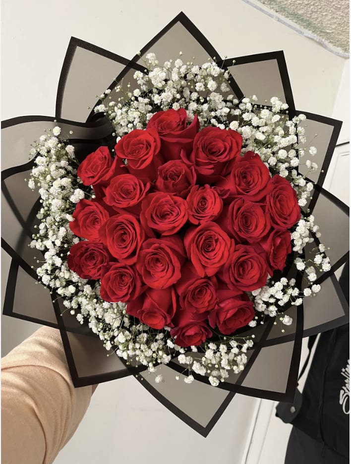 Bouquet of red roses with white baby's breath in black wrap