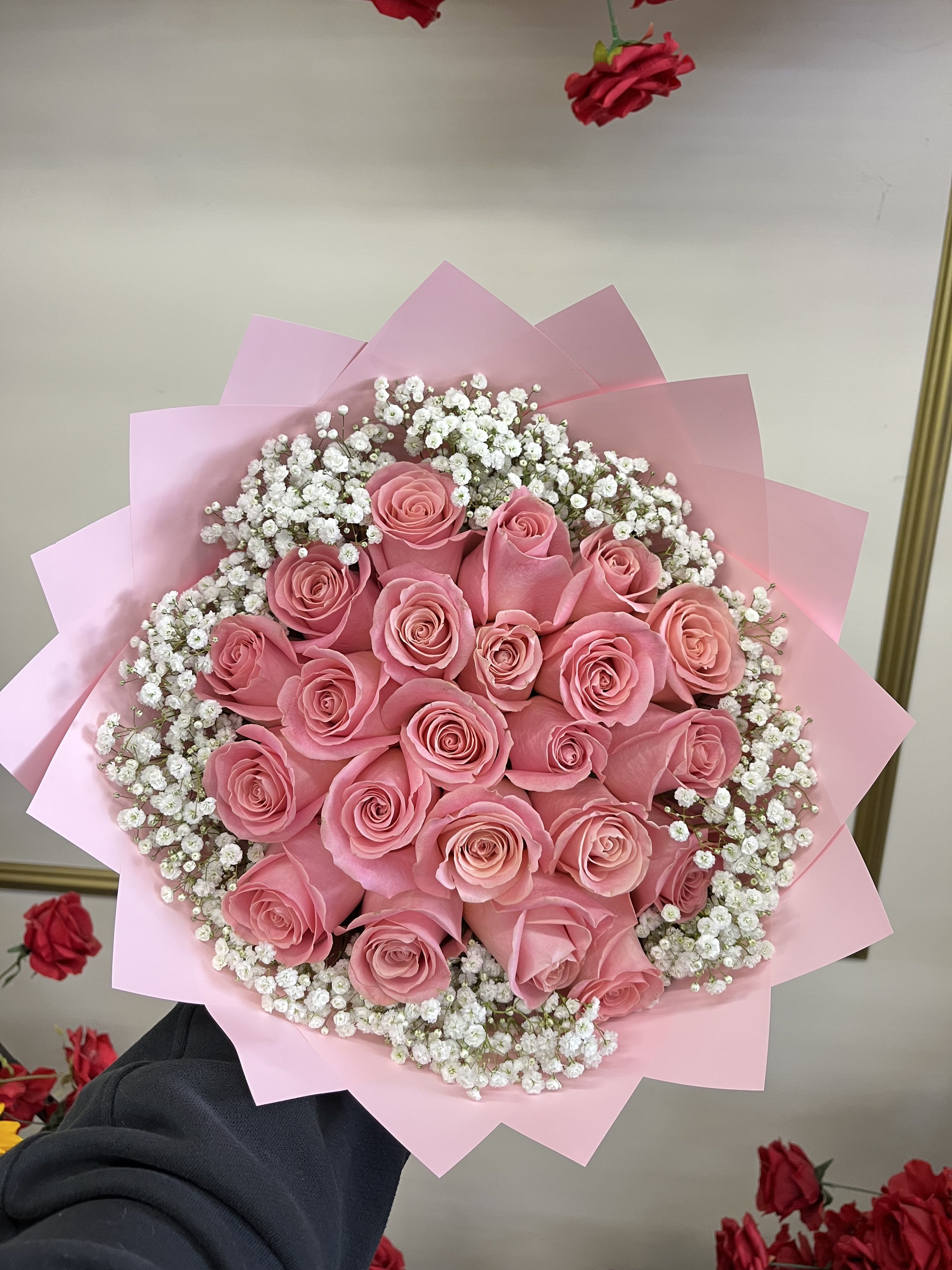 Bouquet of pink roses with white baby's breath in pink wrapping