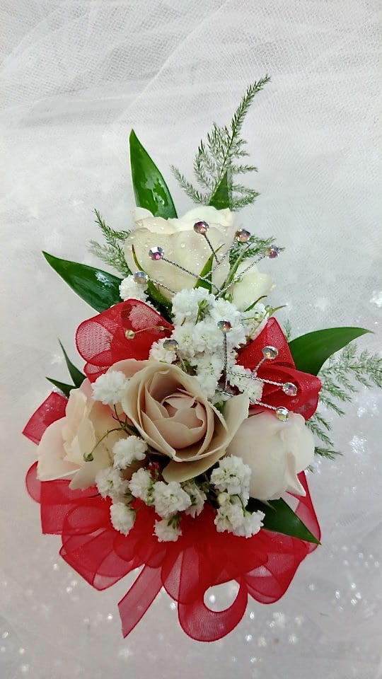 Small bouquet of cream roses with red ribbon and white filler flowers