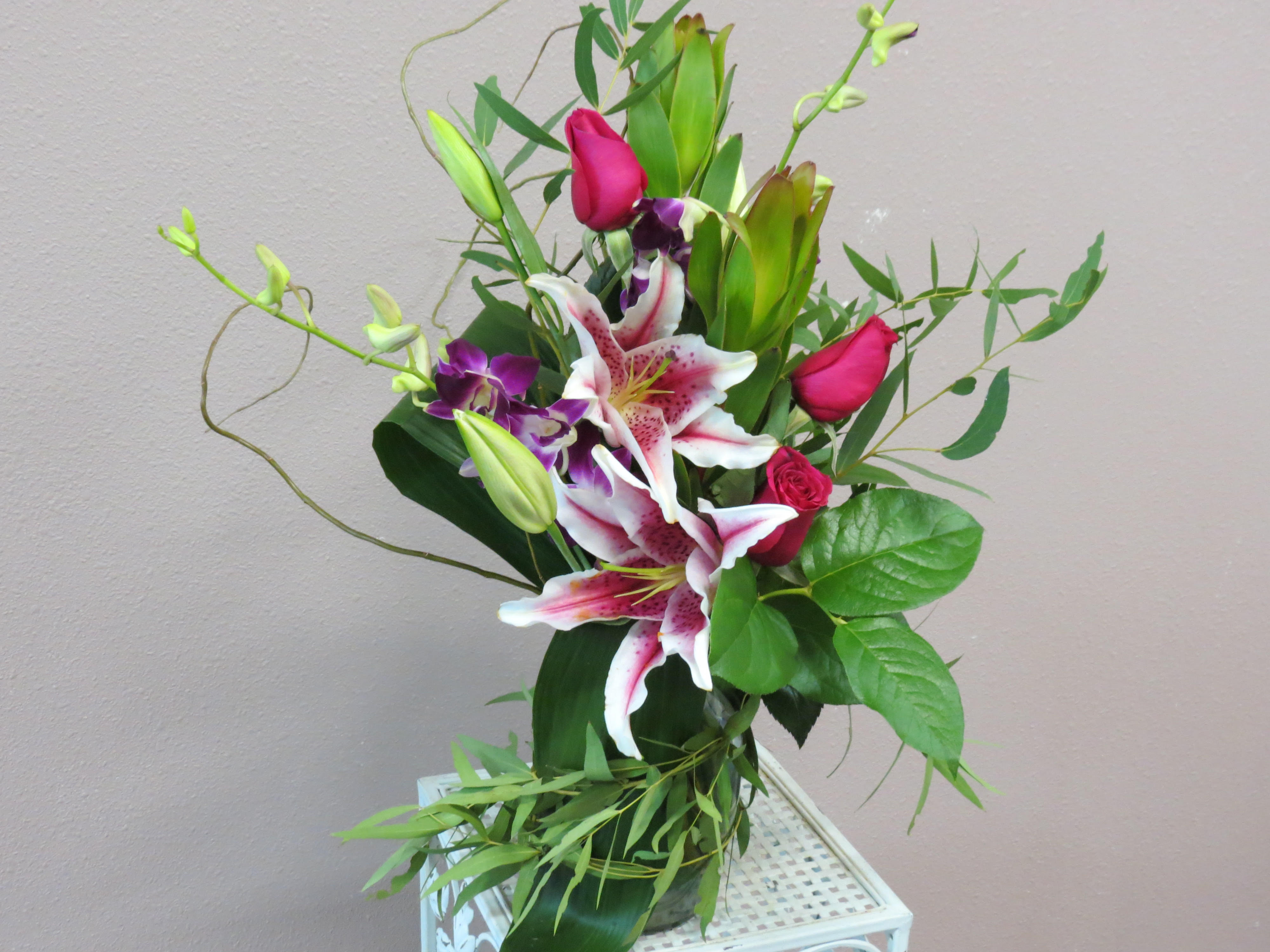 Bouquet of pink roses and white lilies with purple orchids
