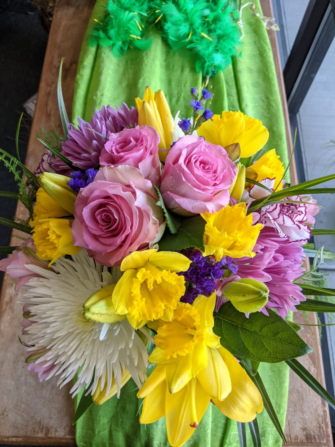 Bouquet of pink roses, yellow daffodils, and purple flowers