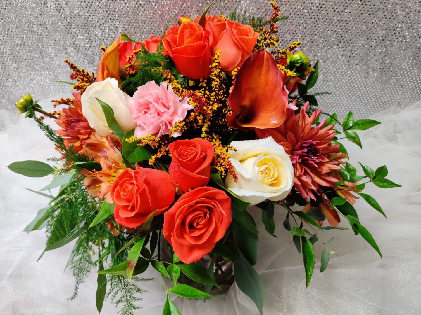 Bouquet of orange and white roses with pink flowers in a vase