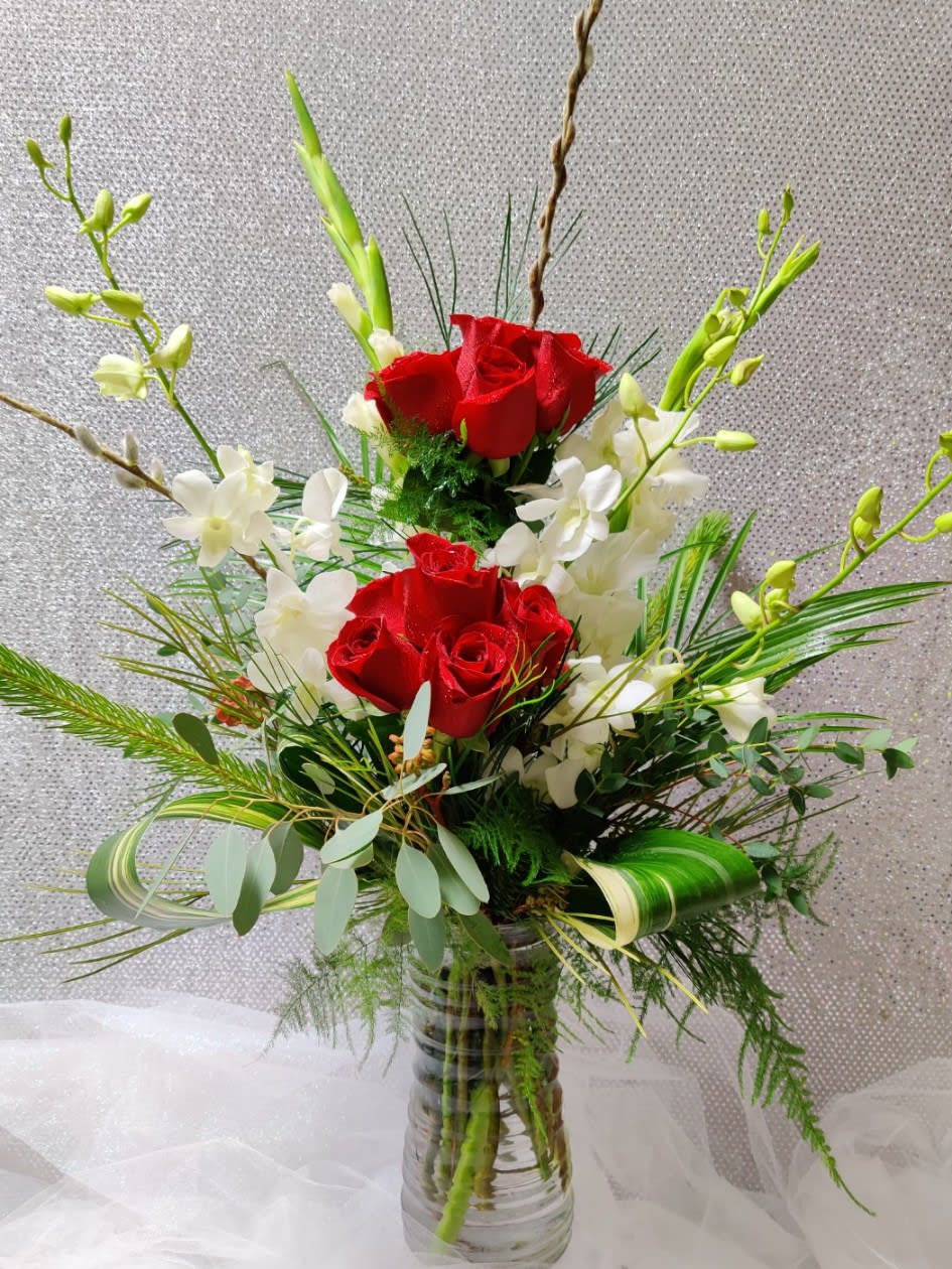Red roses and white orchids in a clear glass vase