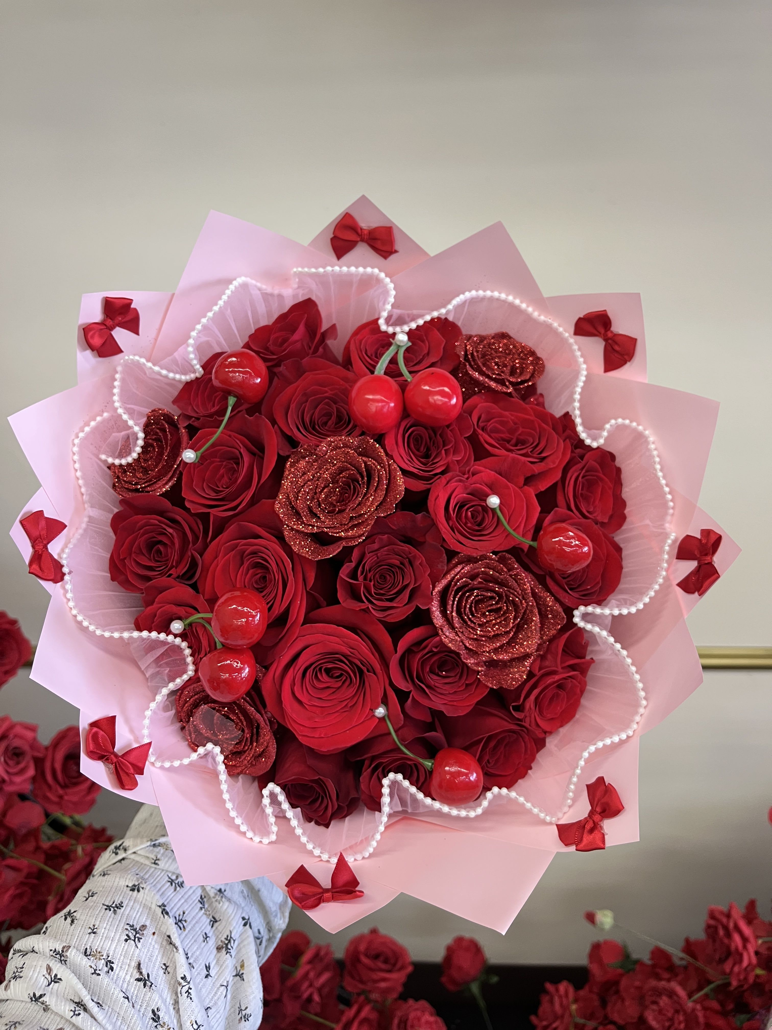 Bouquet of red roses with pink wrapping and red ribbon bows