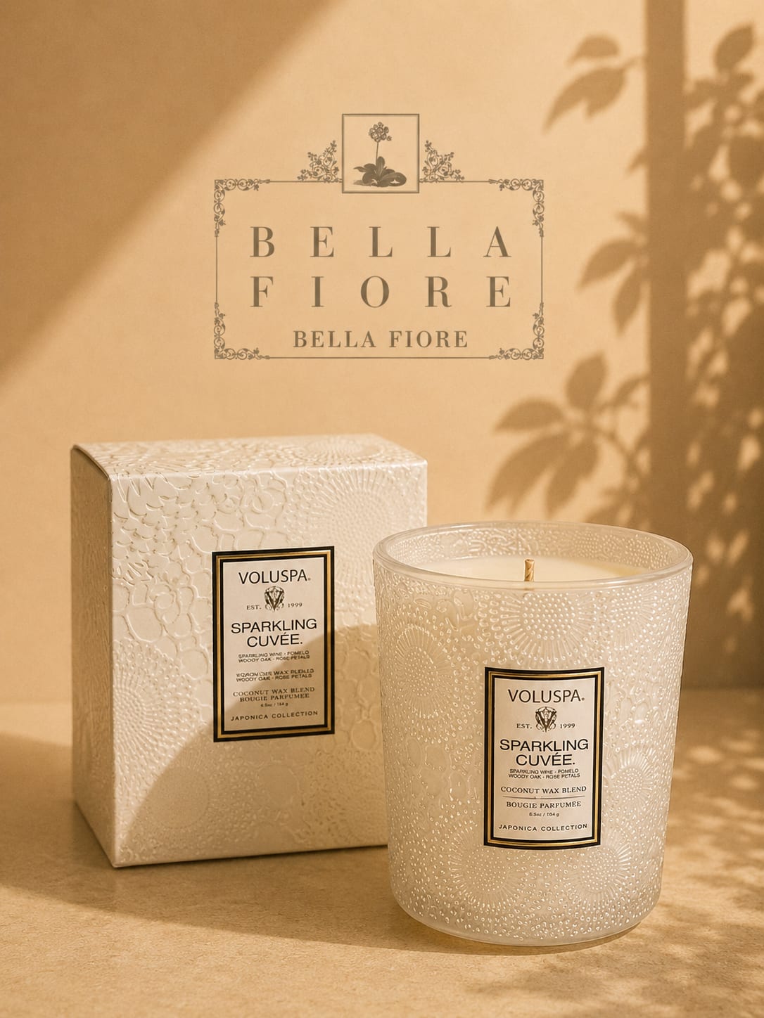 Two decorative scented candles in textured glass containers with a matching box