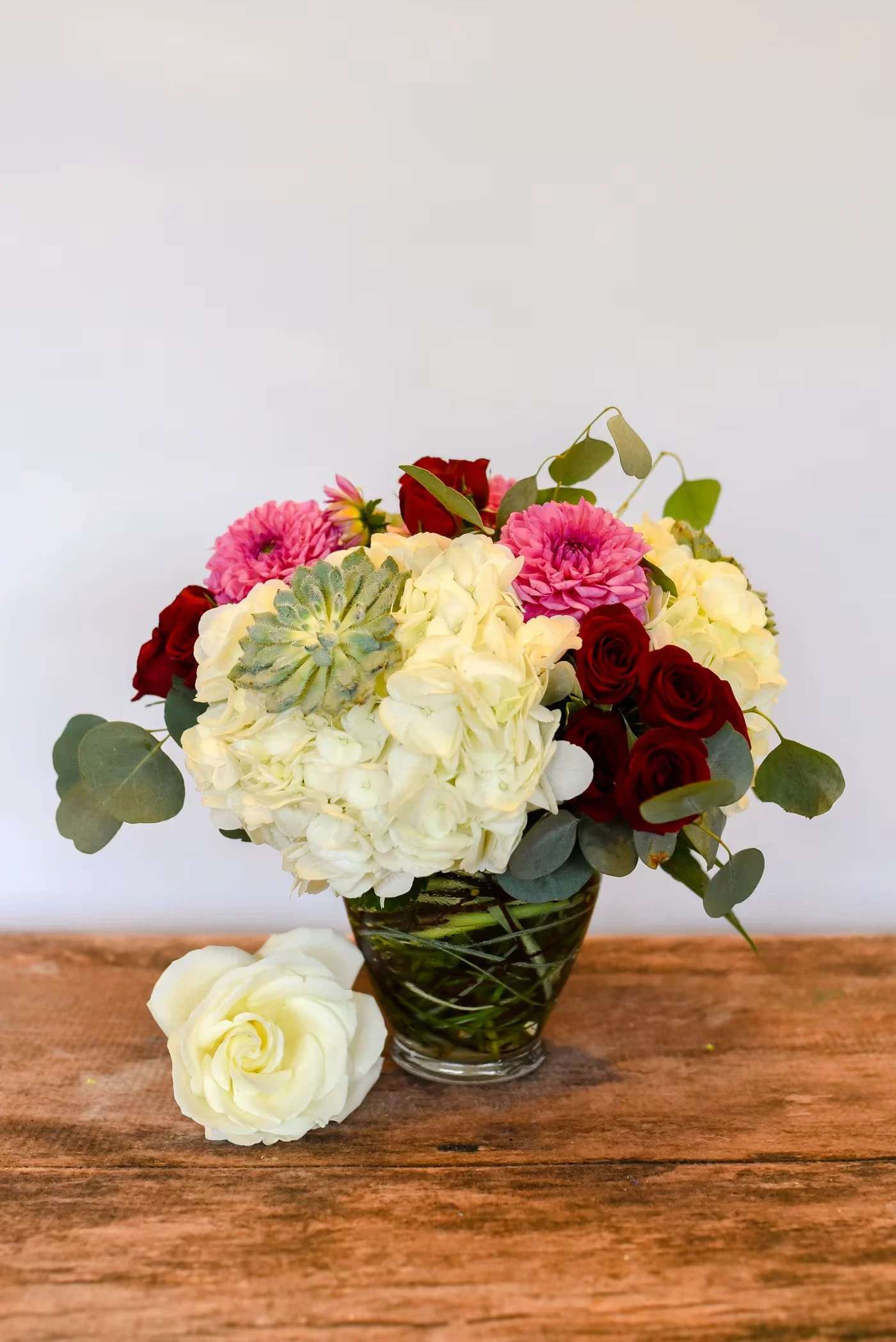 Bouquet of white hydrangeas and red roses in a glass vase
