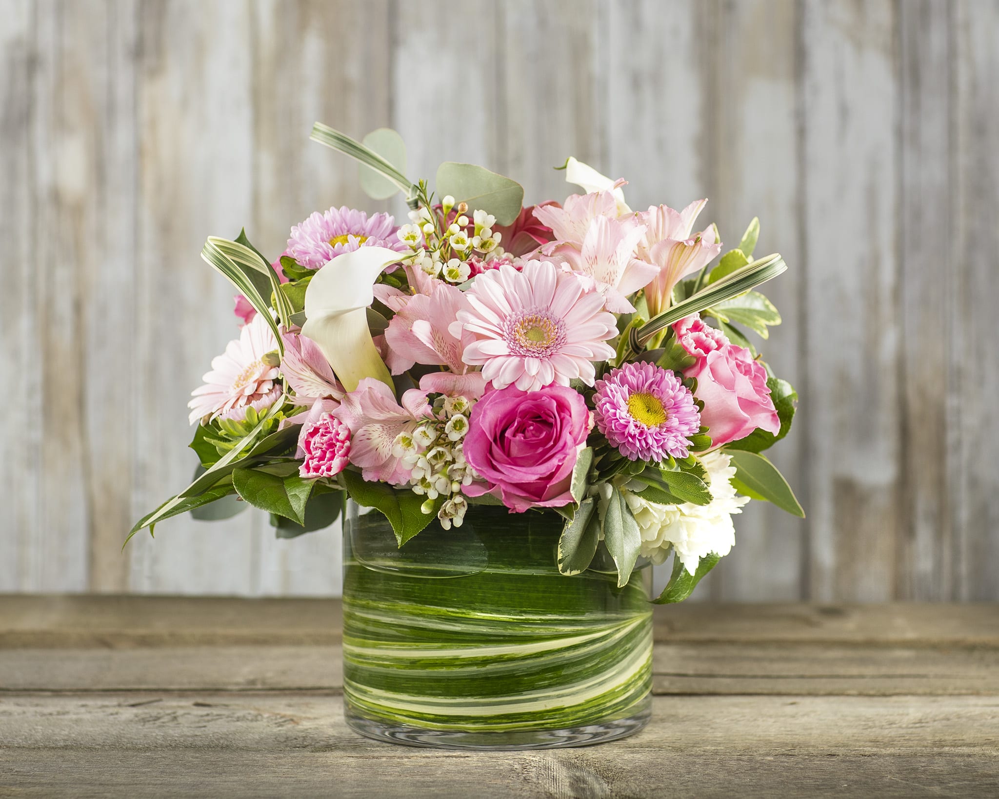 Pink mixed flowers arranged in a glass vase