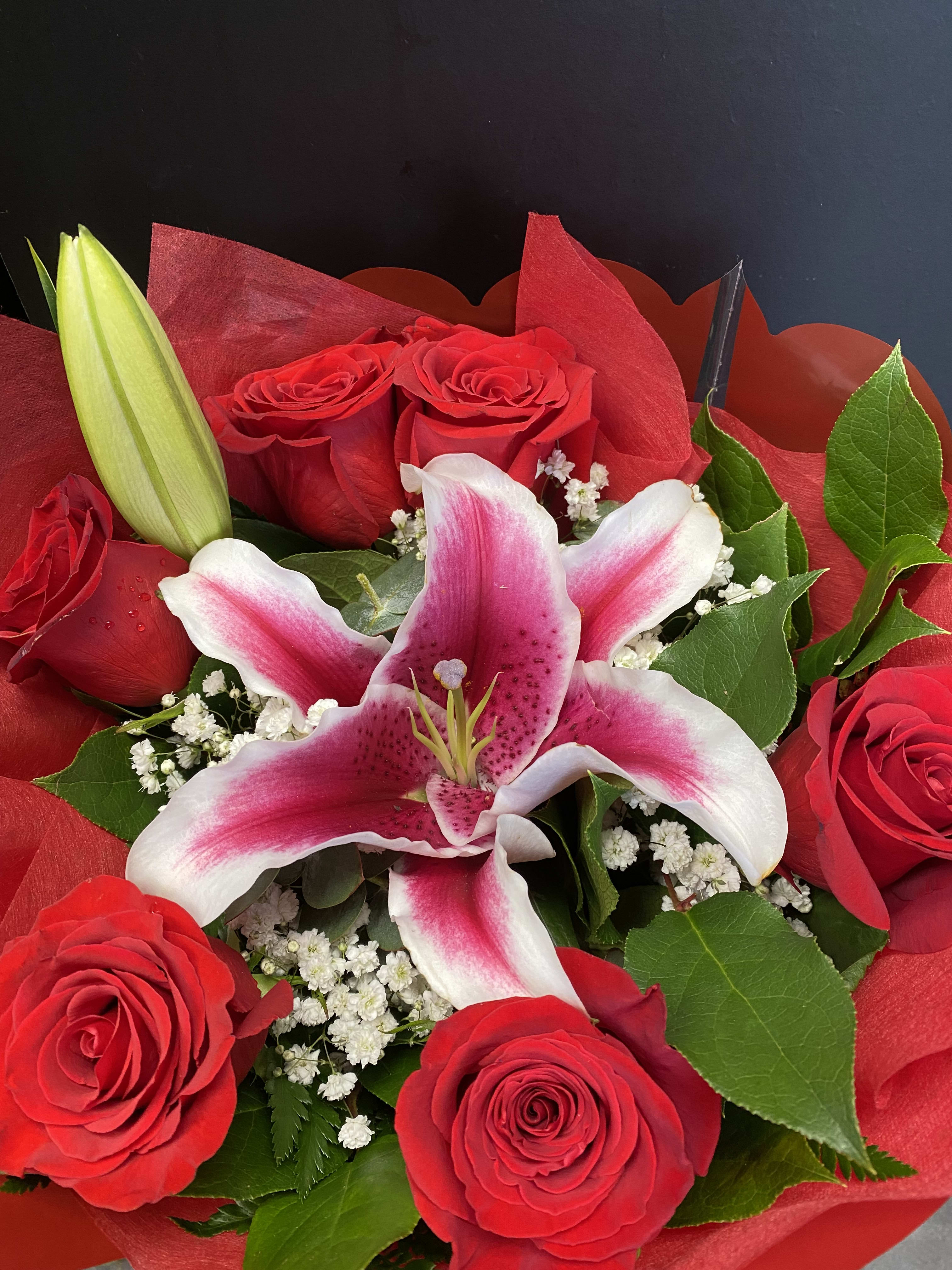 Bouquet of red roses and a pink-and-white lily