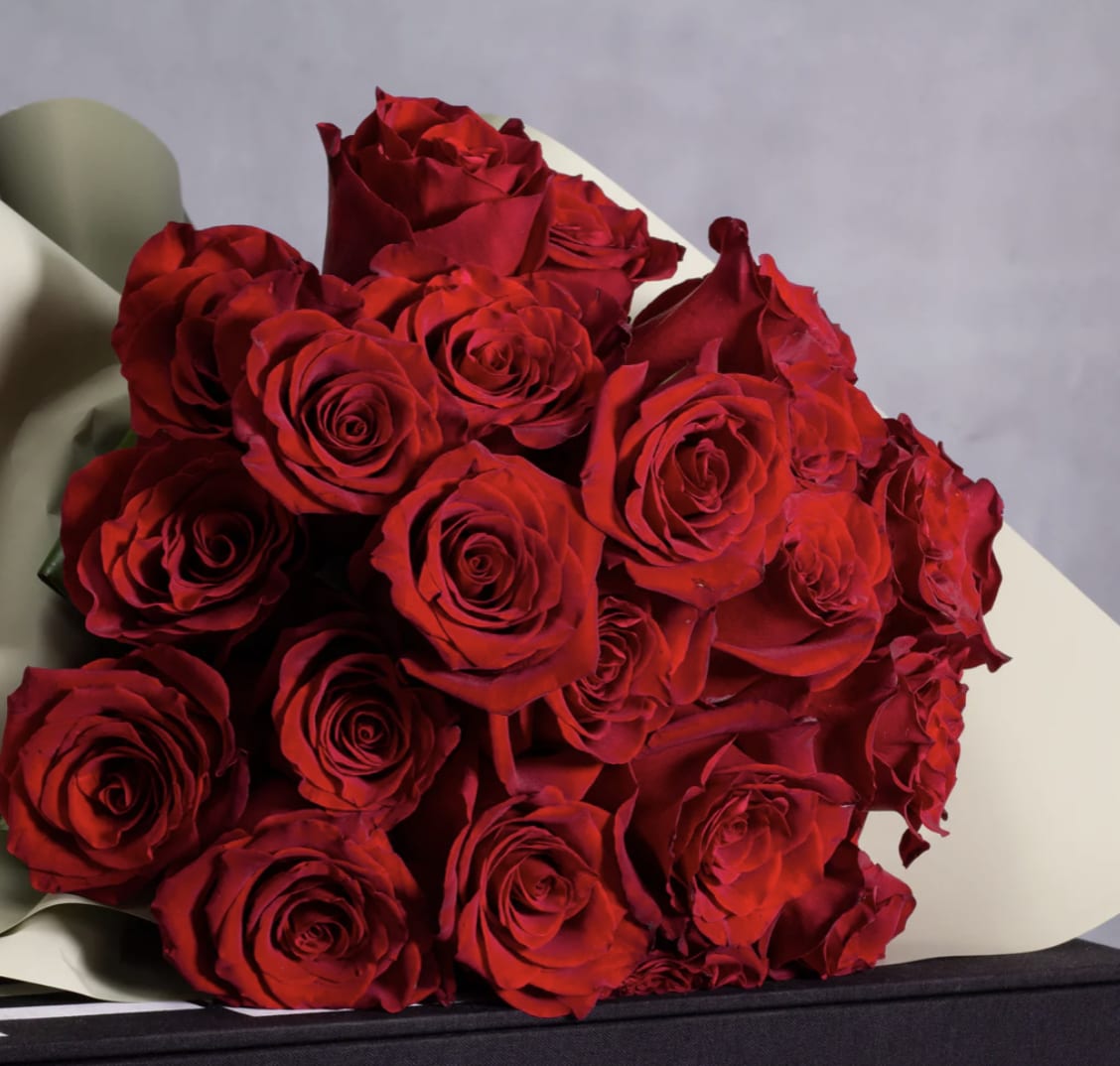 Bouquet of red roses wrapped in pale paper