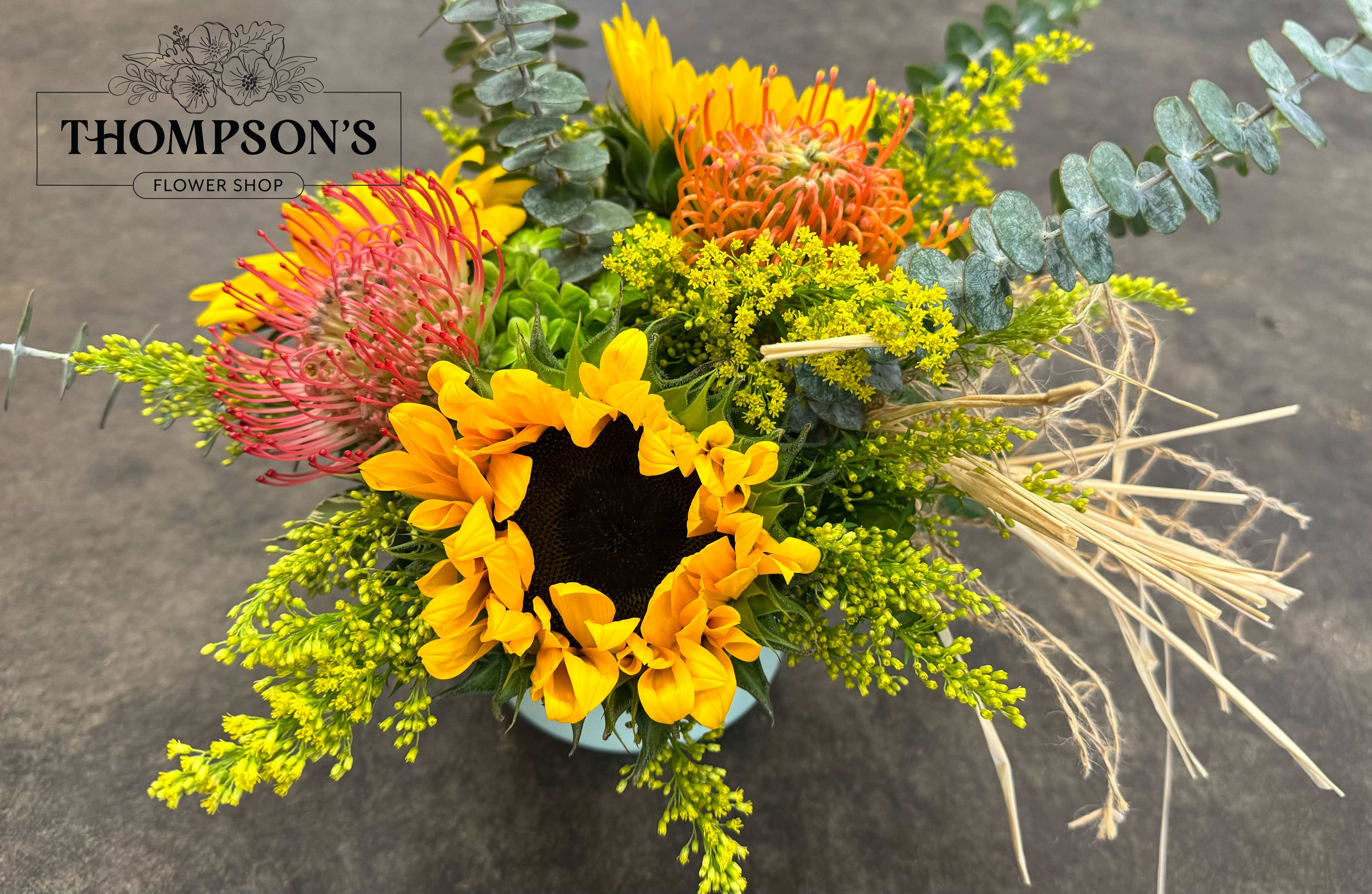 Bright mixed bouquet with a sunflower and pink, orange, and yellow blooms