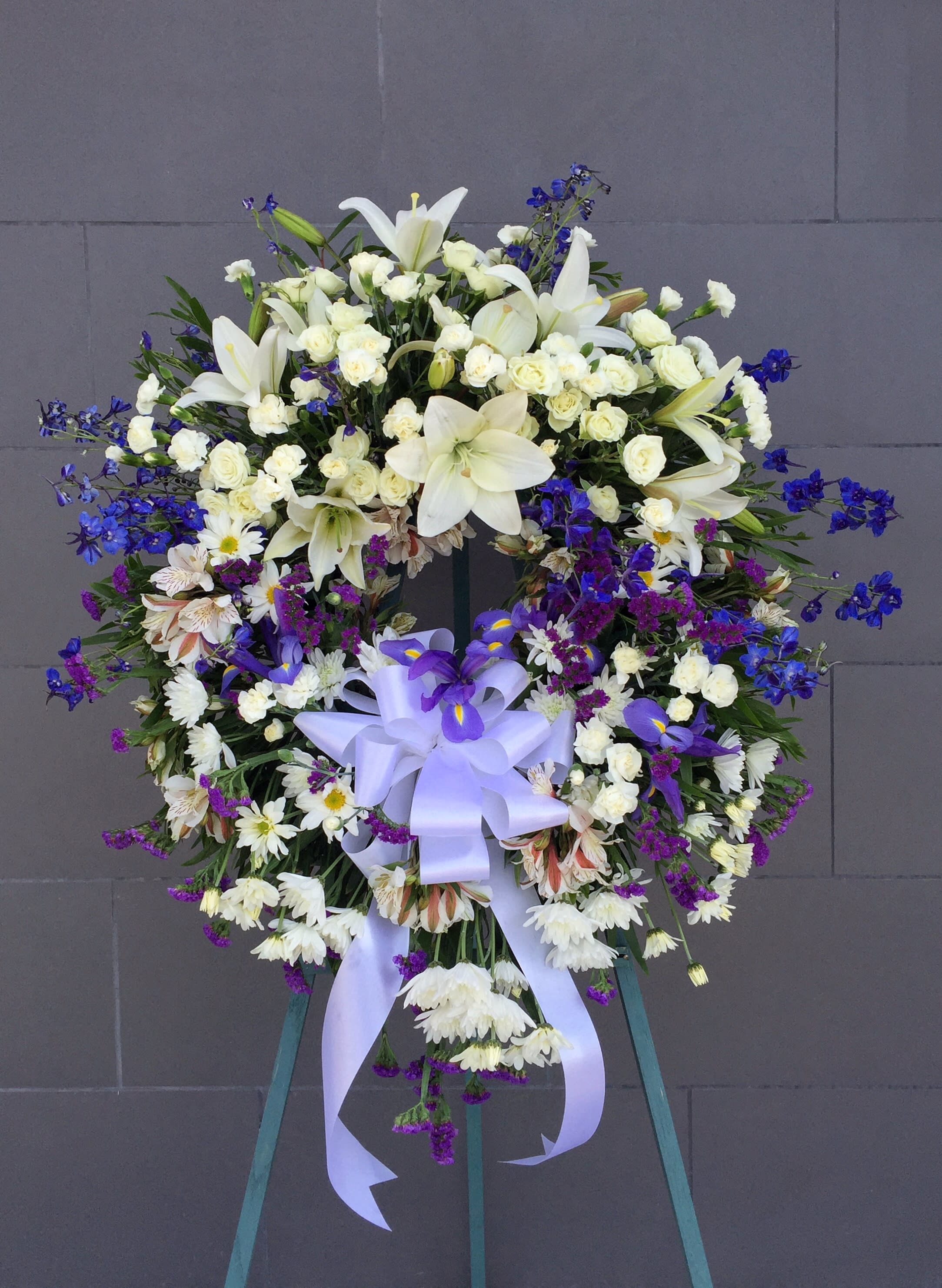 Large white and purple funeral wreath with a lavender ribbon