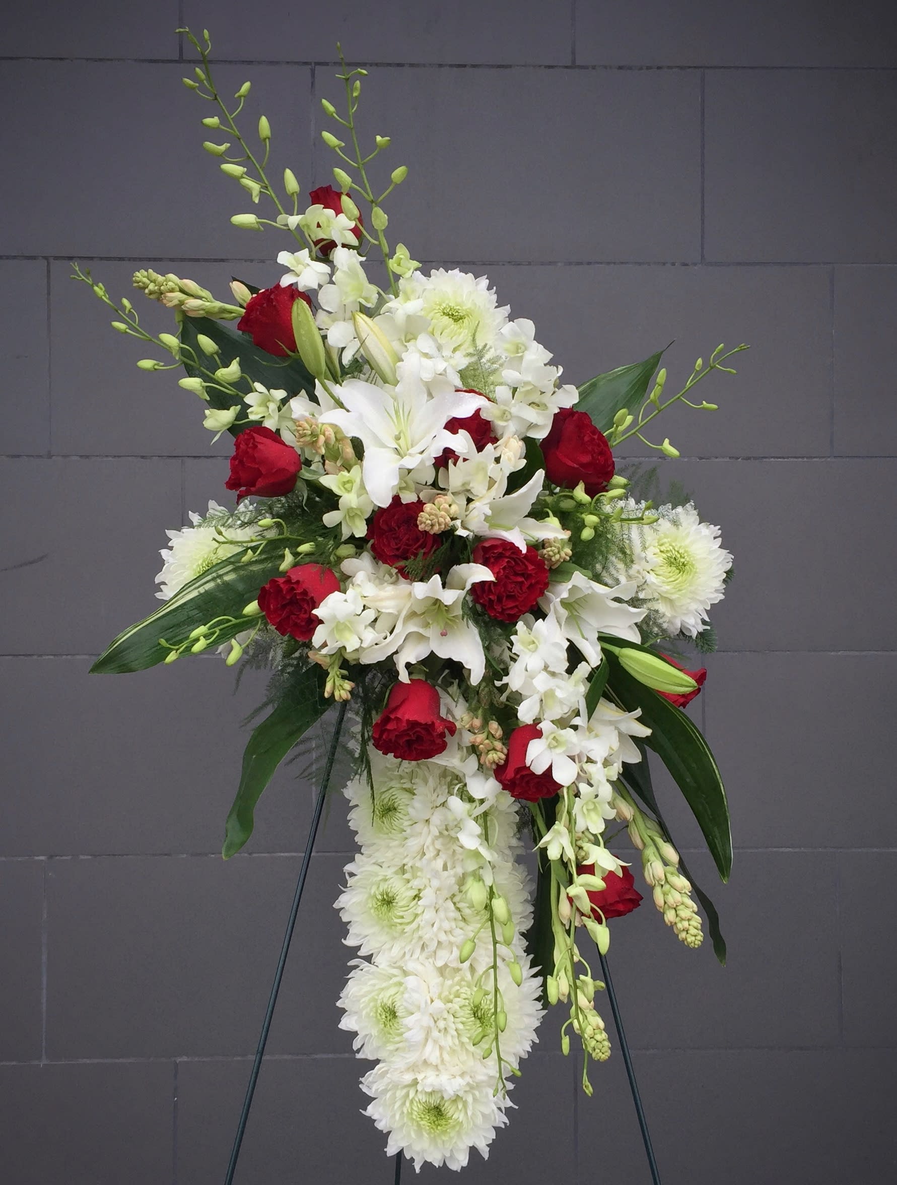 Standing floral spray with red roses, white lilies, and white chrysanthemums