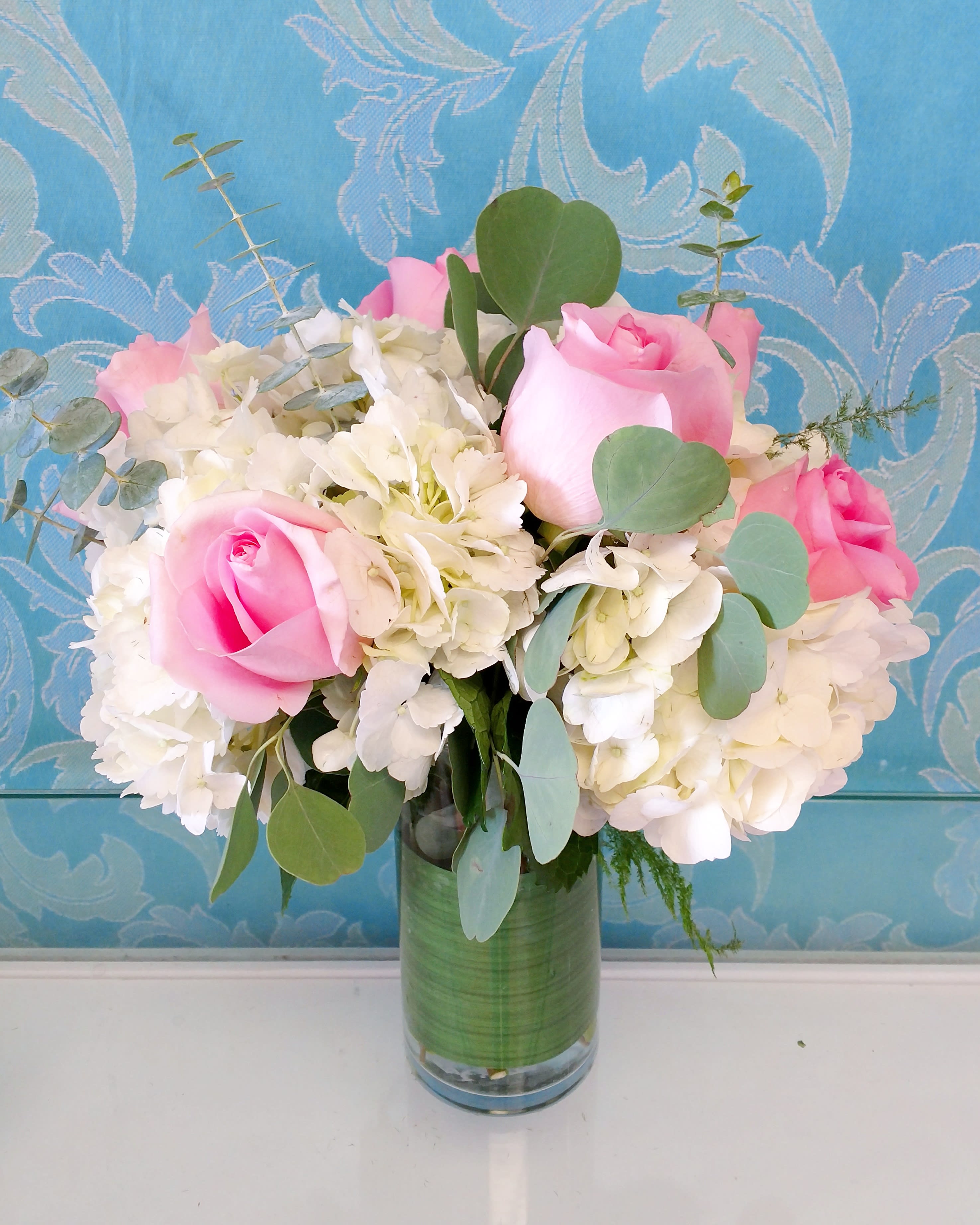 Pink roses and white hydrangeas in a glass vase