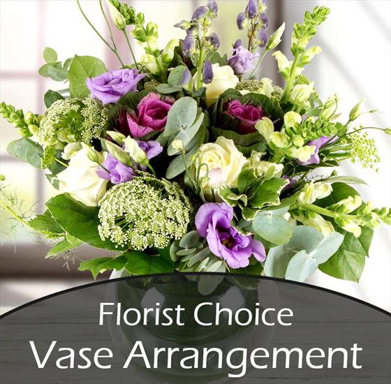 Mixed purple, white, and green flowers in a vase arrangement