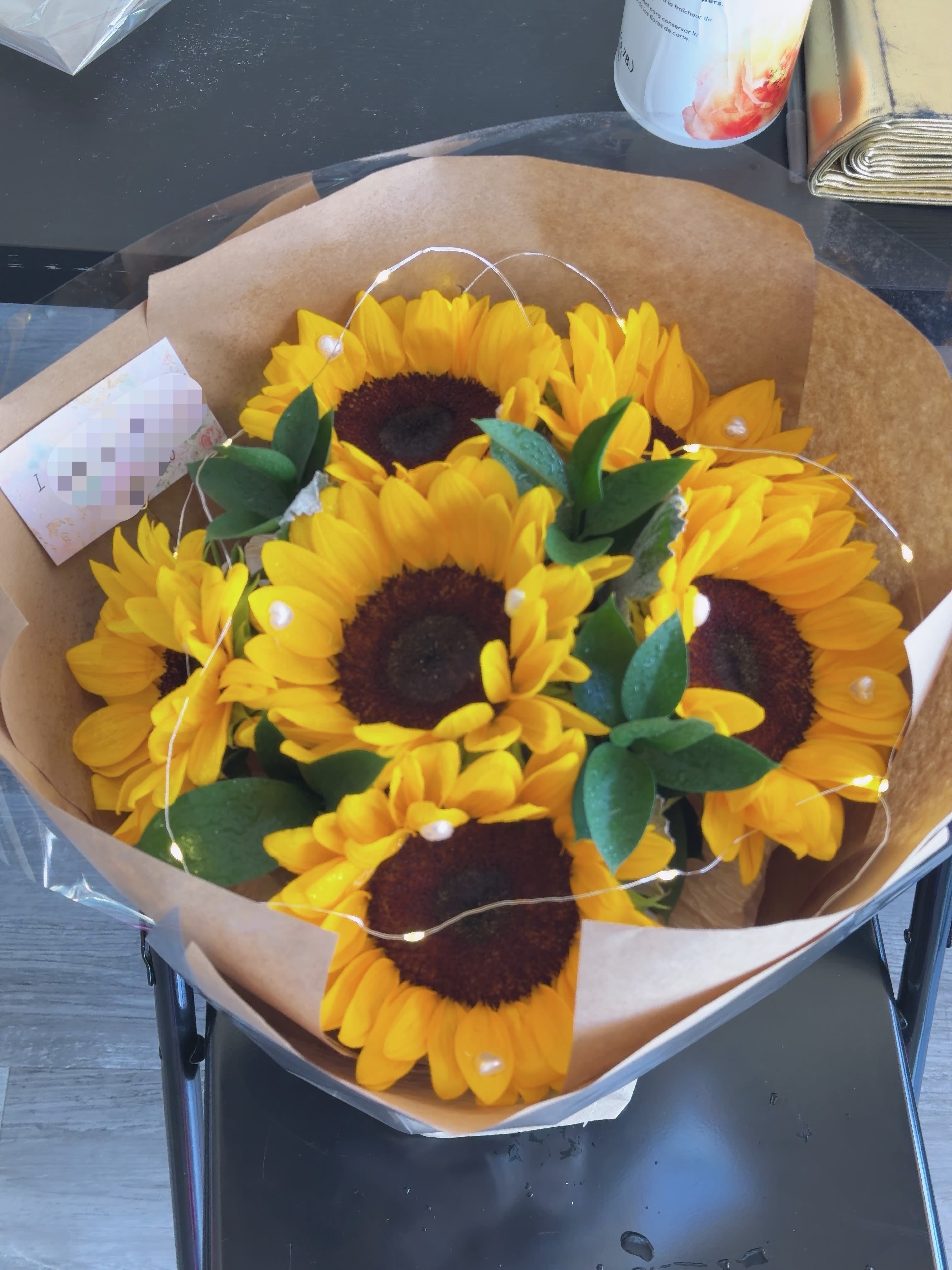 Sunshine Glow Bouquet - Bring warmth and happiness with our Sunshine Glow Bouquet. This bouquet features vibrant artificial sunflowers wrapped in elegant kraft paper, creating a cheerful and cozy atmosphere for any occasion.   Includes:  * Premium artificial sunflowers * Decorative greenery * Elegant wrapping * One mini string light for a warm glowing effect  Perfect for:  * Birthday gifts * Graduation celebrations * Home decoration * Anniversary surprises * Photo props