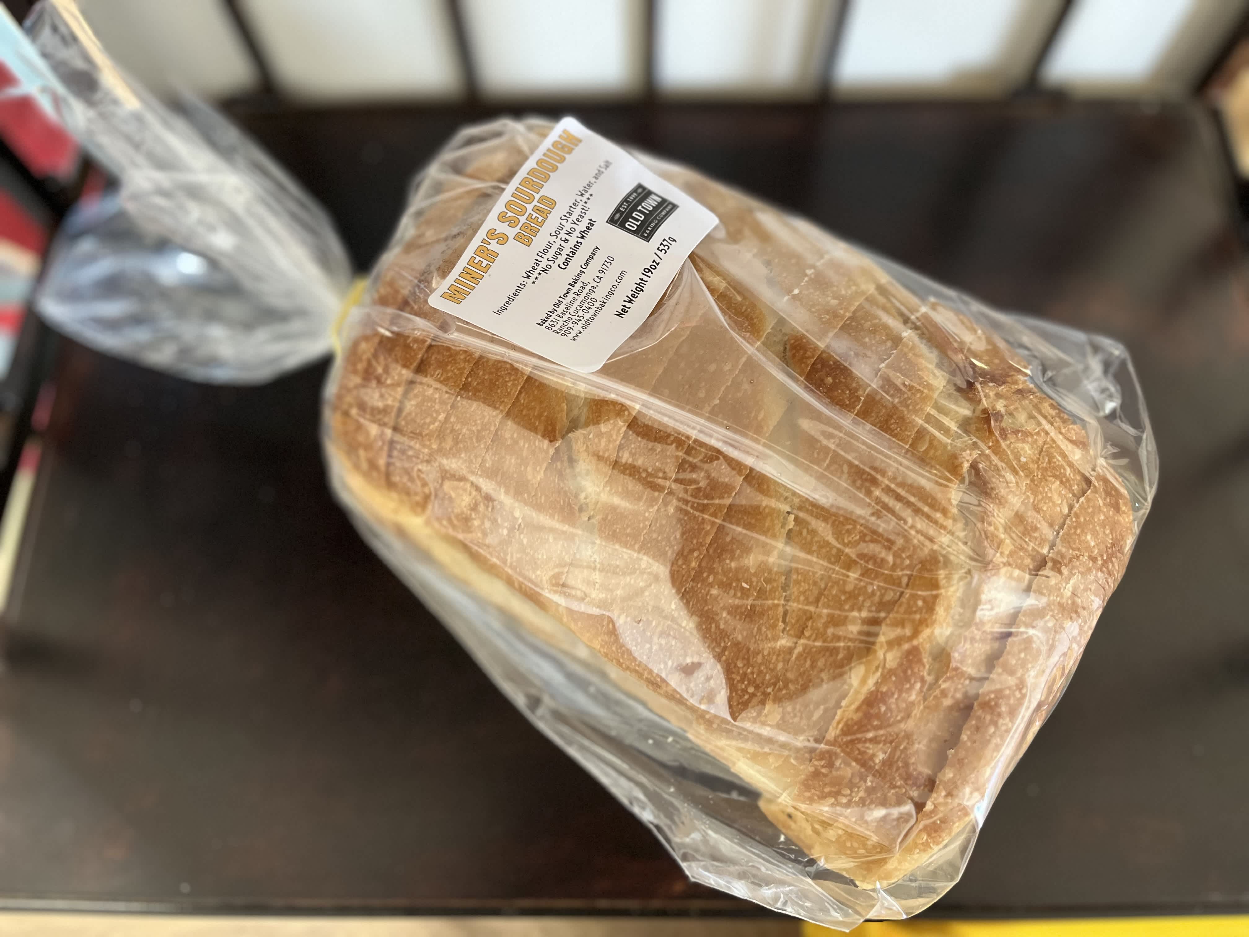Loaf of sourdough bread in plastic wrap with a label
