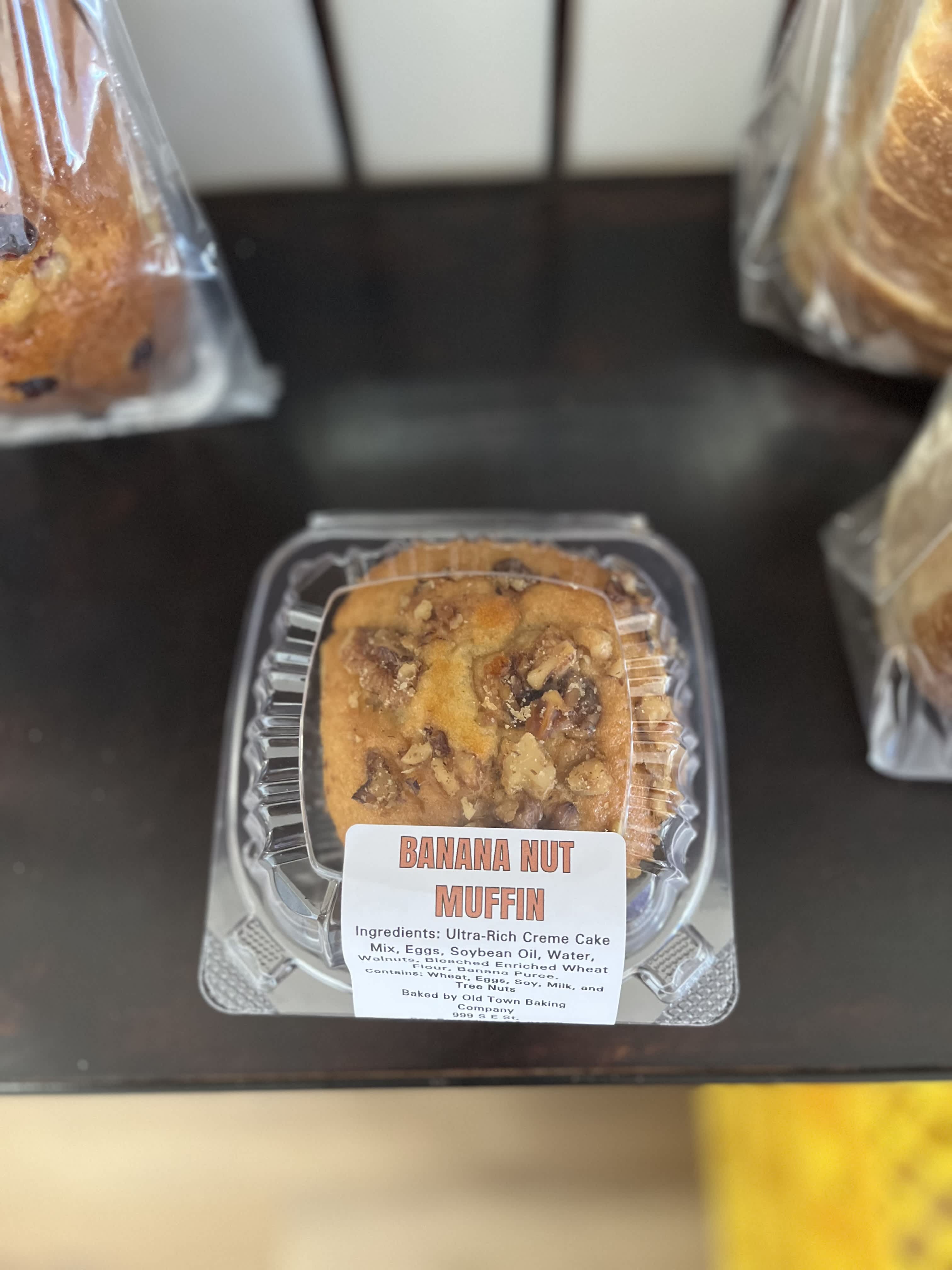 Banana nut muffin in a clear plastic clamshell container