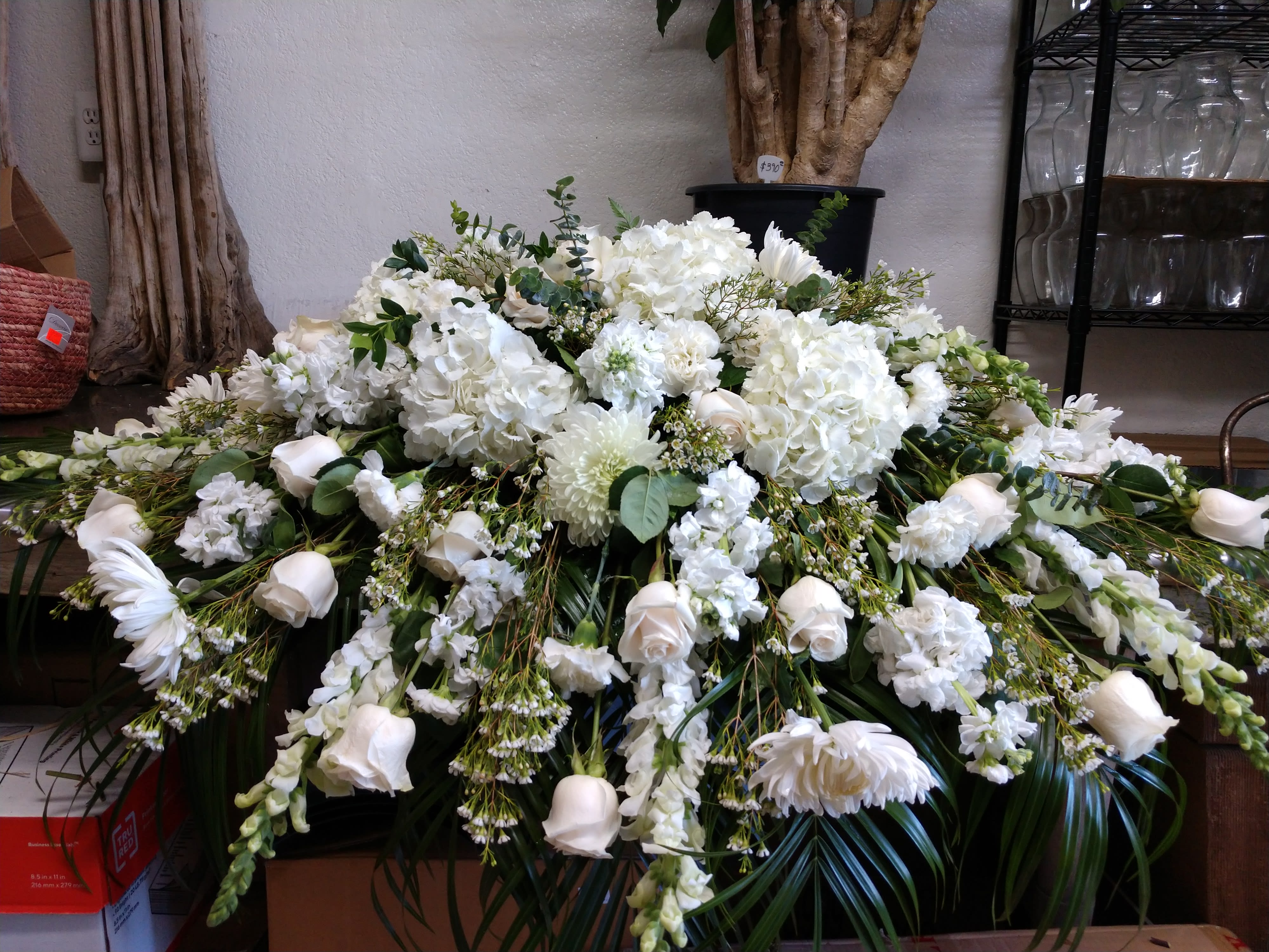 Large white funeral spray with roses, hydrangeas, and chrysanthemums