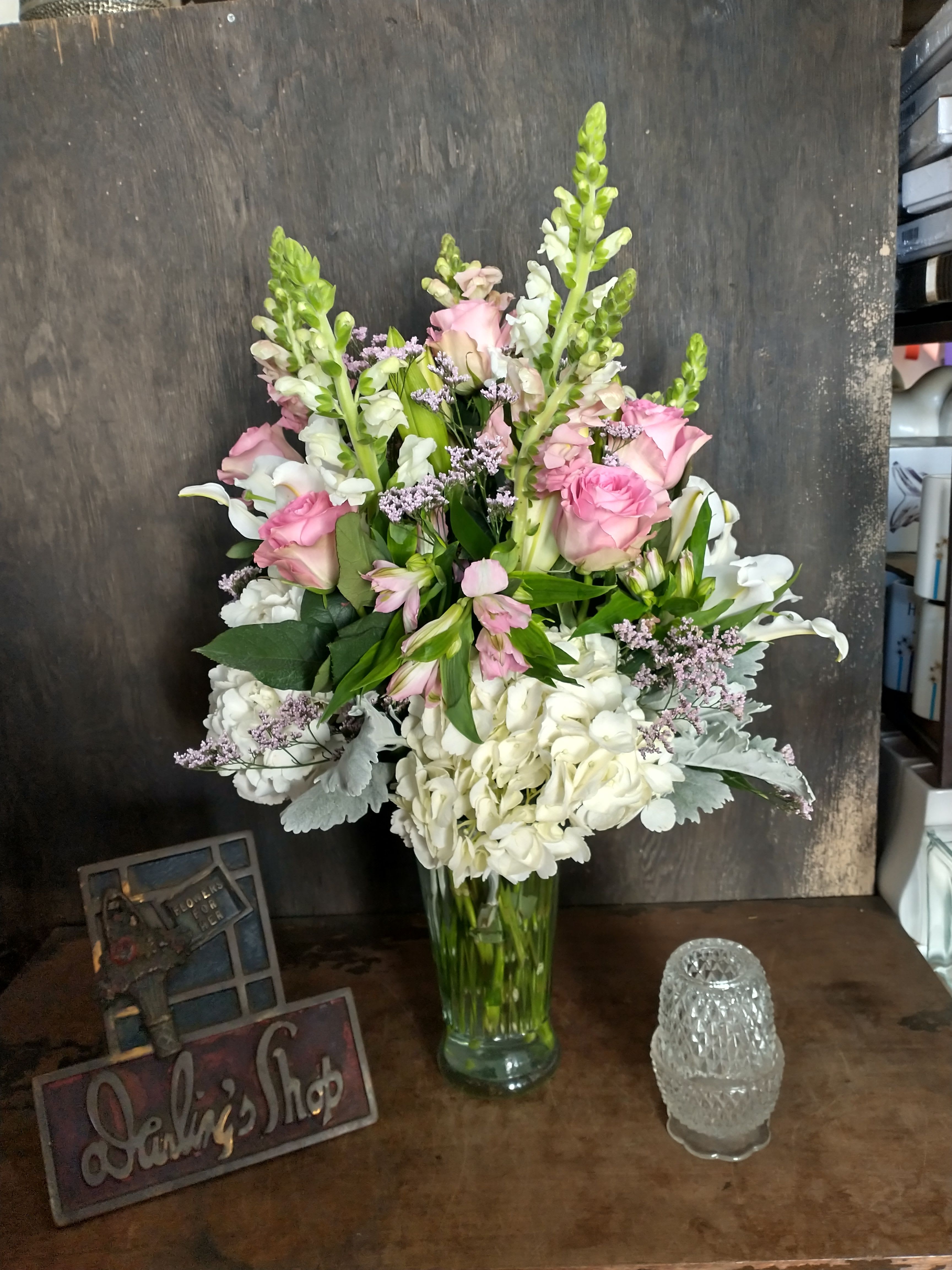 Pink roses and white flowers arranged in a clear glass vase
