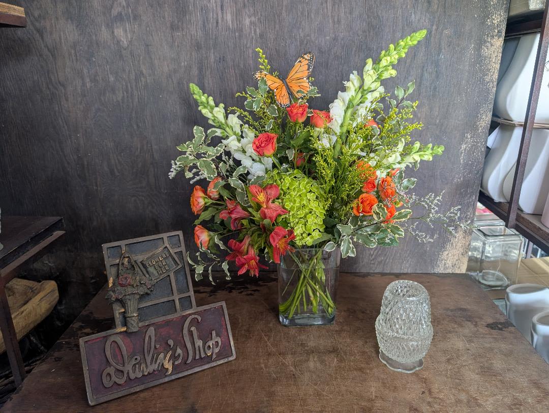Happy Orange Blooms - Bright orange roses and playful butterfly picks give this mixed-color bouquet a cheerful lift-perfect as a birthday bouquet, congratulations arrangement, or spring celebration gift. The tall, airy composition places white snapdragon spikes and pink-and-orange blooms above a vivid green hydrangea cluster so the person you're thinking of will immediately feel noticed and celebrated.