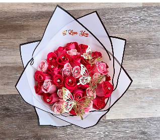 Bouquet of pink and red roses wrapped in white paper
