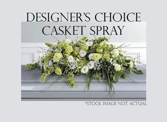 Green and white casket spray with mixed flowers on a gray casket