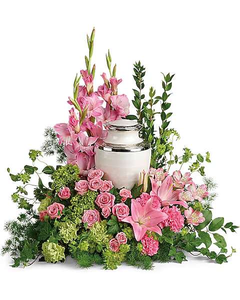 Pink flowers arranged around a silver urn with green foliage