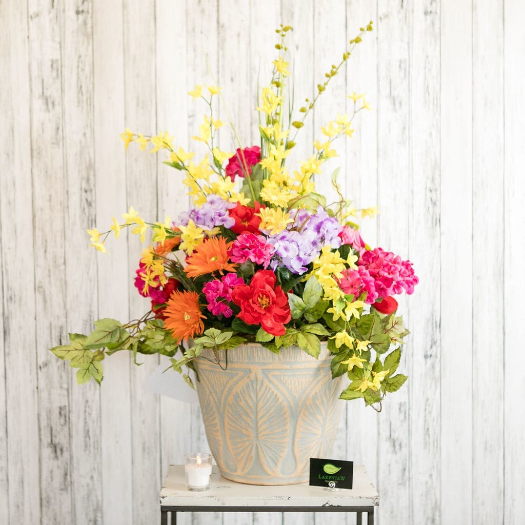 Beyond - A bright and colorful arrangement of artificial memorial flowers, made to withstand Wisconsin summers.  Rest easy at home knowing they will maintain their beauty all season long, with no maintenance required.     Upgrade to Deluxe and include a powder-coated, iron stand for permanent use that most cemeteries require.  Approximate Dimensions: 40" H x 24" W