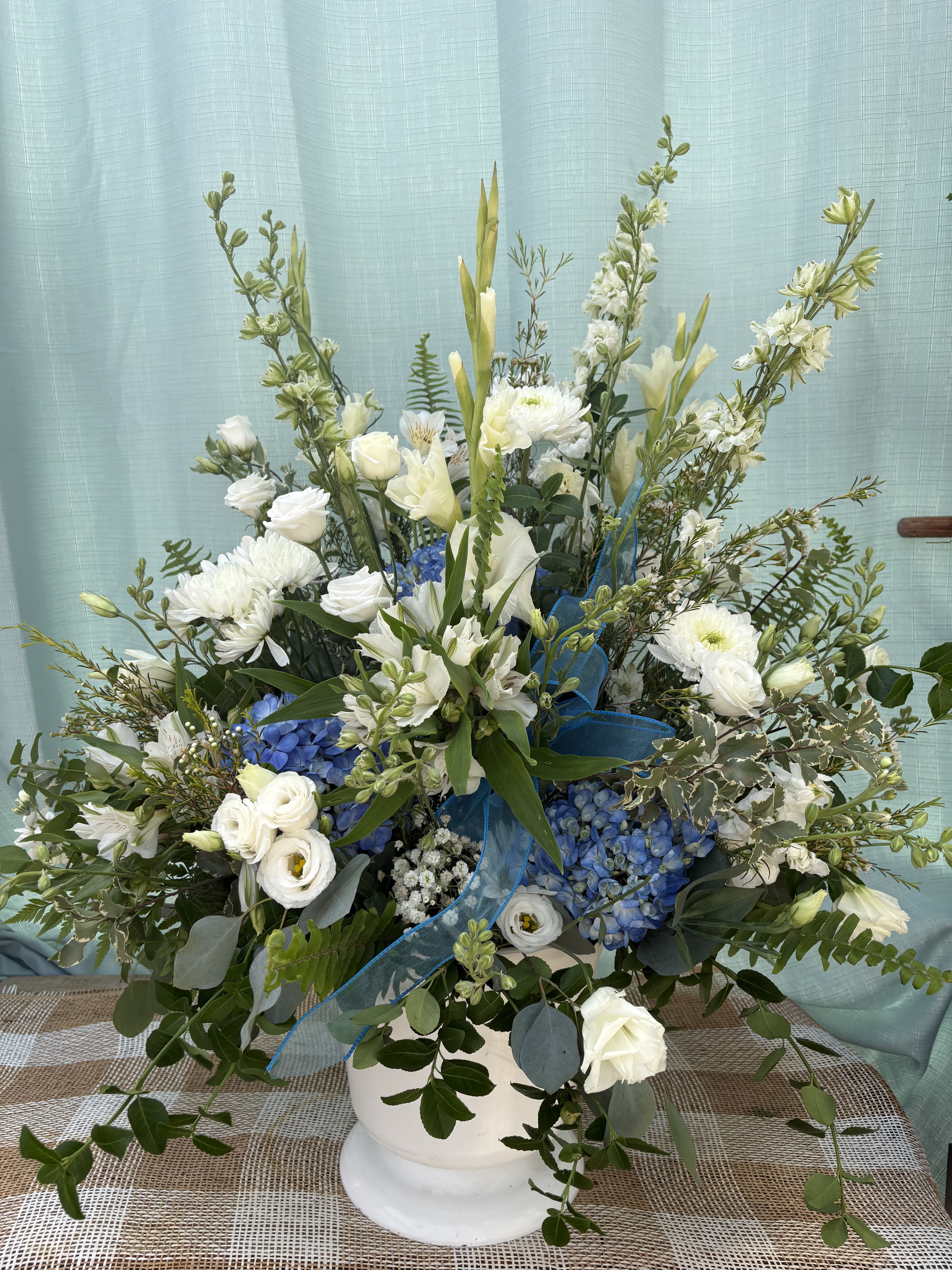 ETERNAL FEELINGS - A stunning blue, classic-style funeral piece with soft blues and creams. Perfect for honoring the memories of passed loved ones.