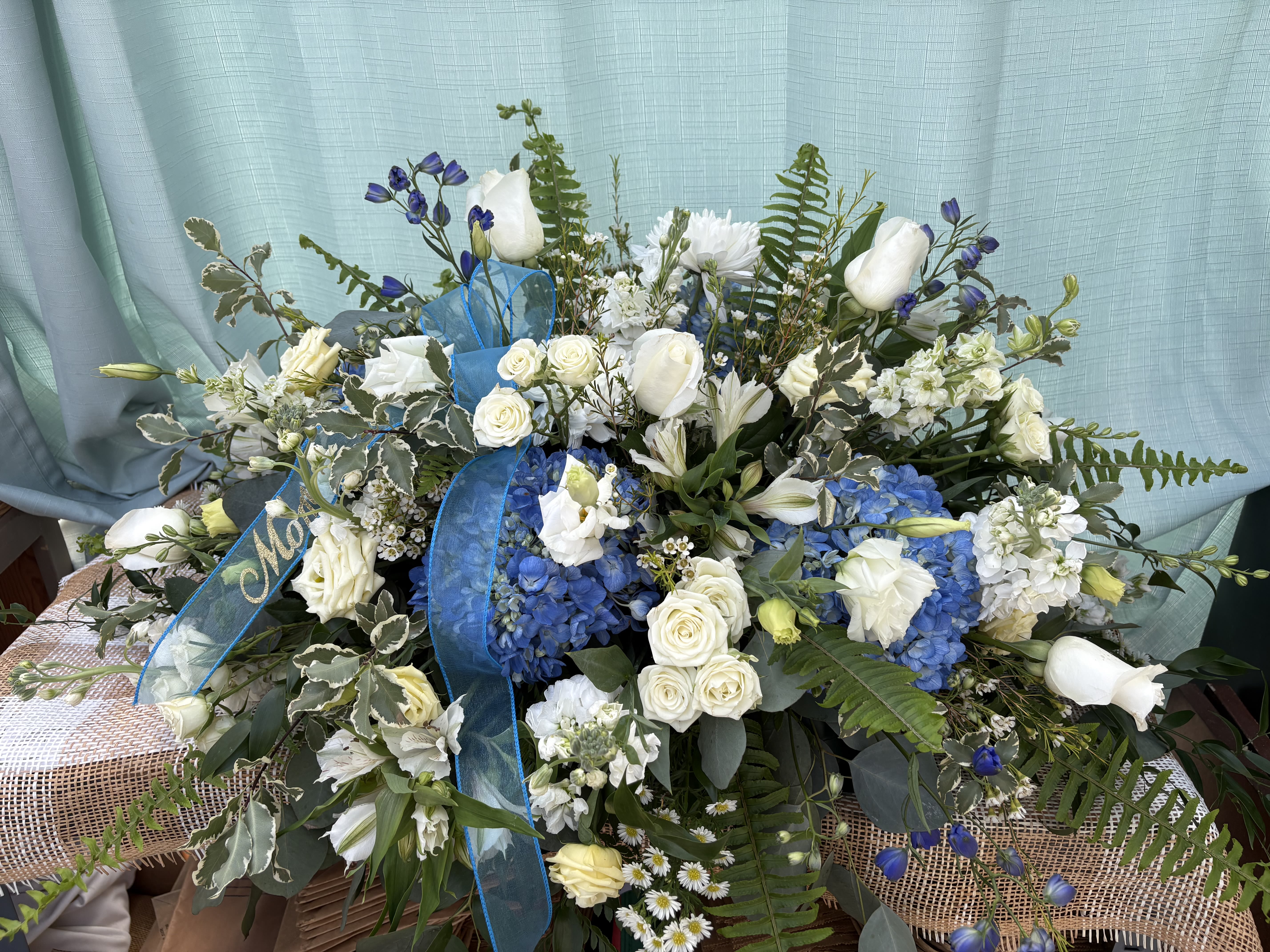 UNDYING LOVE - A soft blue funeral piece in a classical style that serves as a perfect way to show unending love for those who have passed.