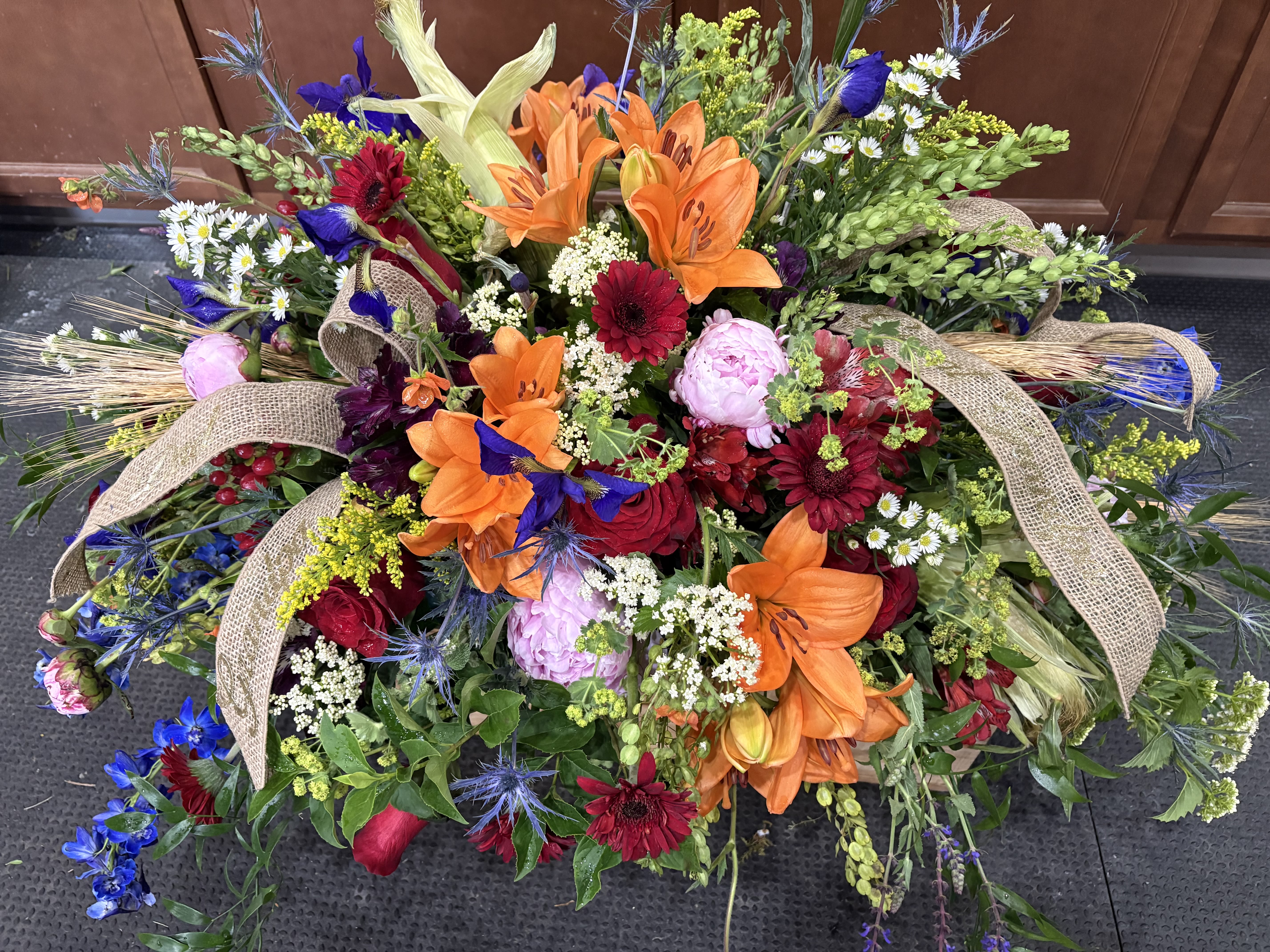 COUNTLESS WAYS - A bold funeral piece with multicolor flowers to remind those of the countless ways passed loved ones have changed lives.