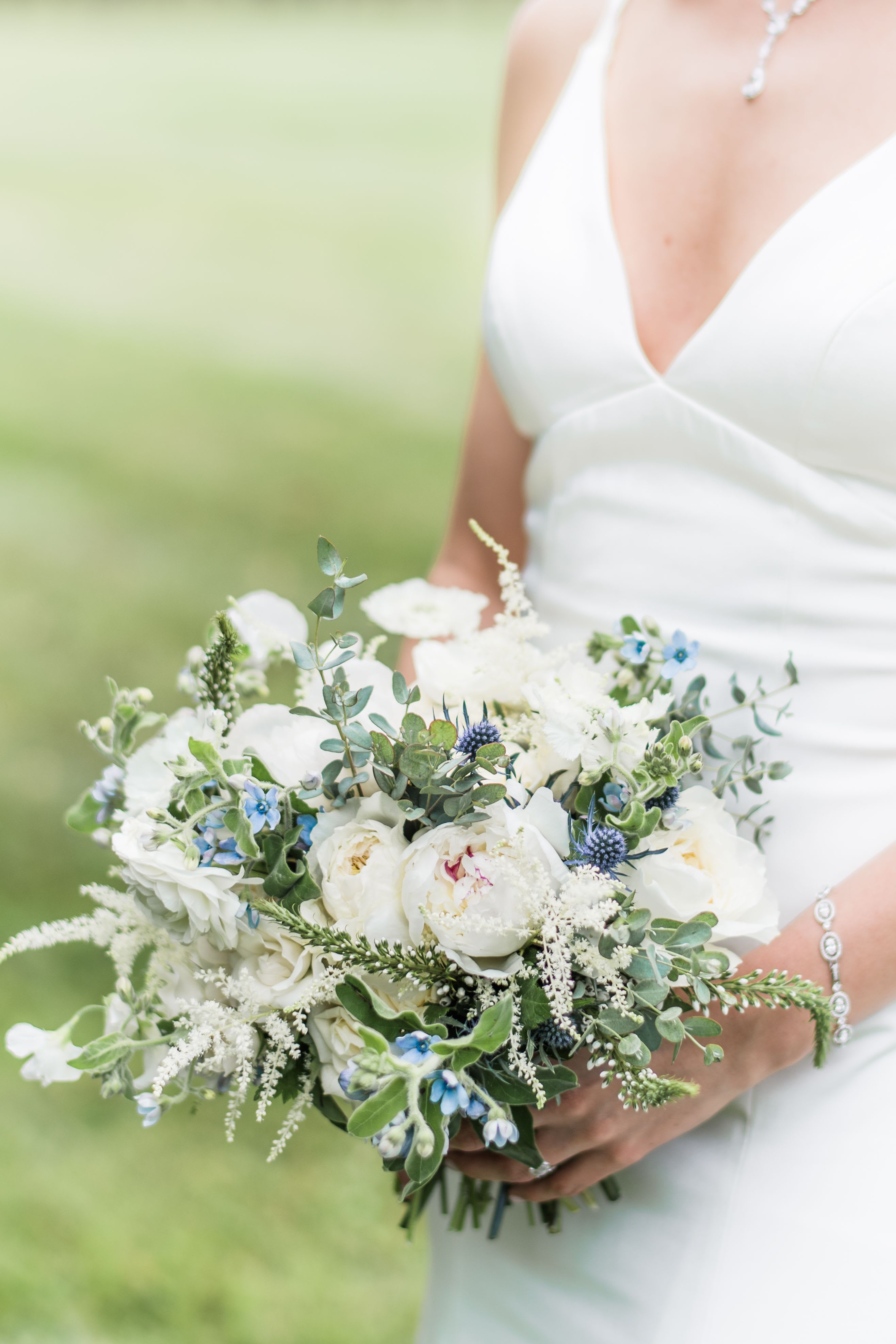 Bride holding a white and blue wedding bouquet