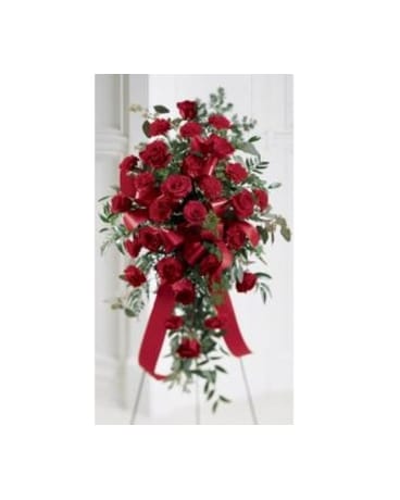Tall standing spray of red roses with red ribbon on a metal easel.