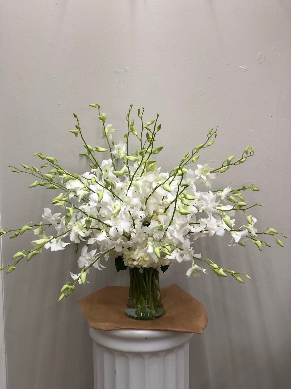 White orchid arrangement in a clear glass vase