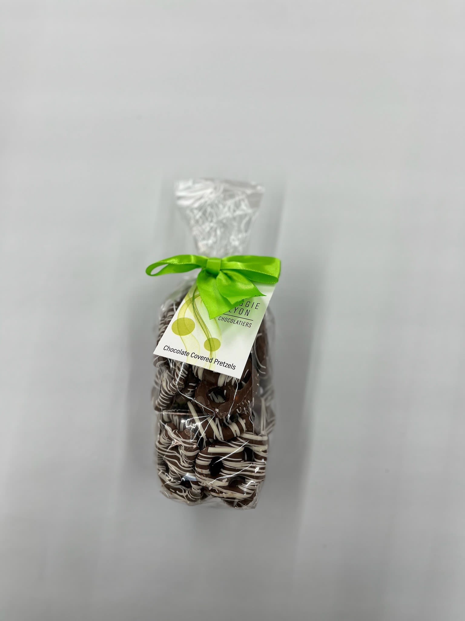 Bag of chocolate-covered pretzels tied with a green ribbon