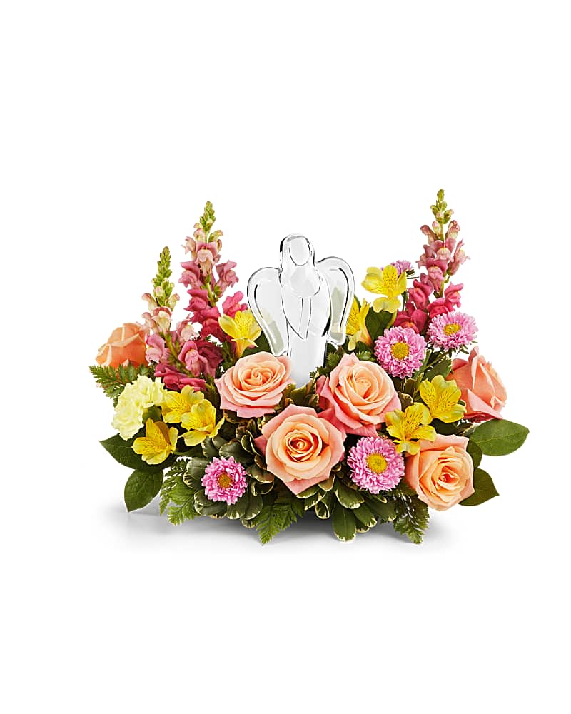Angel's Embrace Bouquet - Radiating peace, comfort, and gentle beauty, Teleflora’s Angel’s Embrace Bouquet surrounds a sparkling crystal angel keepsake with a soft blend of peach roses, pink blooms, and sunny yellow flowers—a graceful tribute to love’s eternal light. Thoughtfully designed in a one-sided arrangement, it offers a heartfelt expression of sympathy, remembrance, or encouragement.  This elegant bouquet features peach roses, yellow alstroemeria, yellow carnations, hot pink snapdragons, and pink Matsumoto asters, beautifully complemented by lush greenery including leatherleaf fern, variegated pittosporum, and lemon leaf. The included crystal angel keepsake adds a lasting touch of comfort and meaning.  Available for delivery in Smyrna, Marietta, Mableton, Austell, and Atlanta.